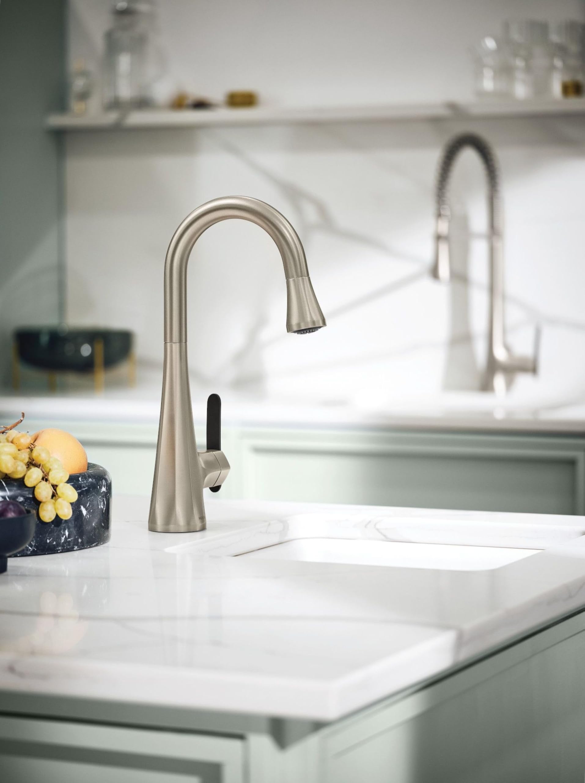 Stainless steel high arc kitchen faucet with single handle and pulldown sprayer mounted on white countertop.