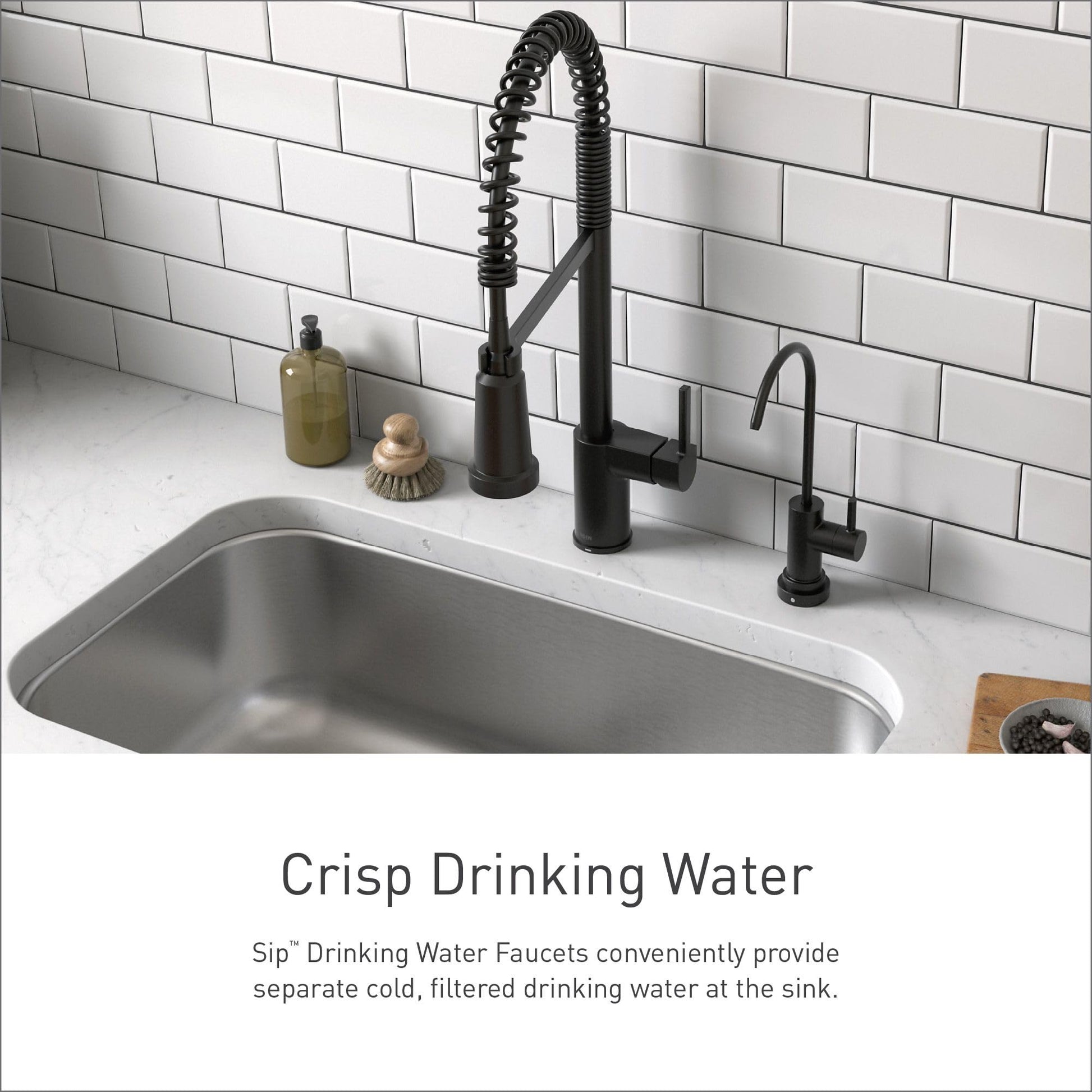 Black stainless steel drinking water faucet with coiled sprayer installed at kitchen sink next to main faucet.