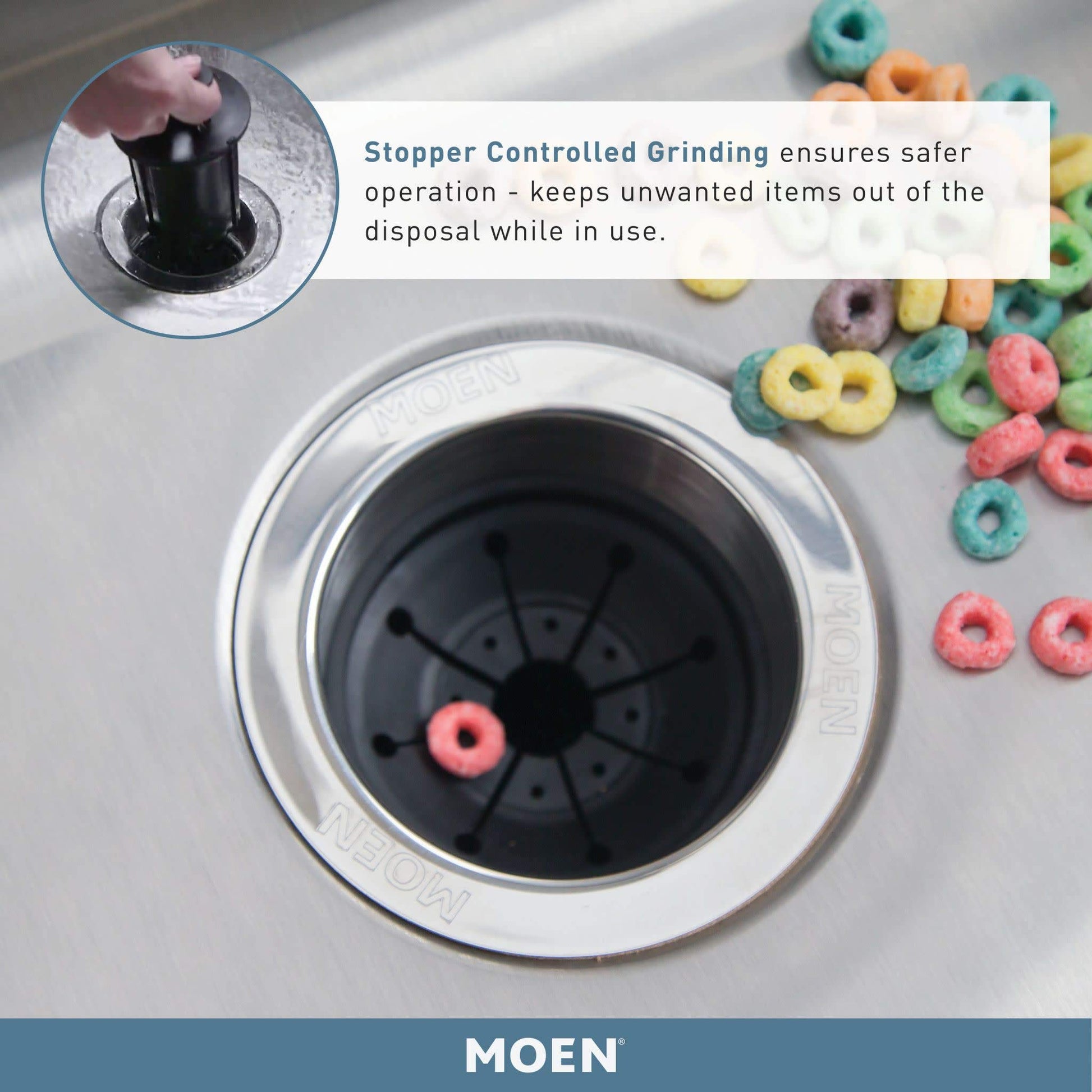Black Moen garbage disposal sink insert with chrome rim and stopper mechanism, shown from above in kitchen sink.