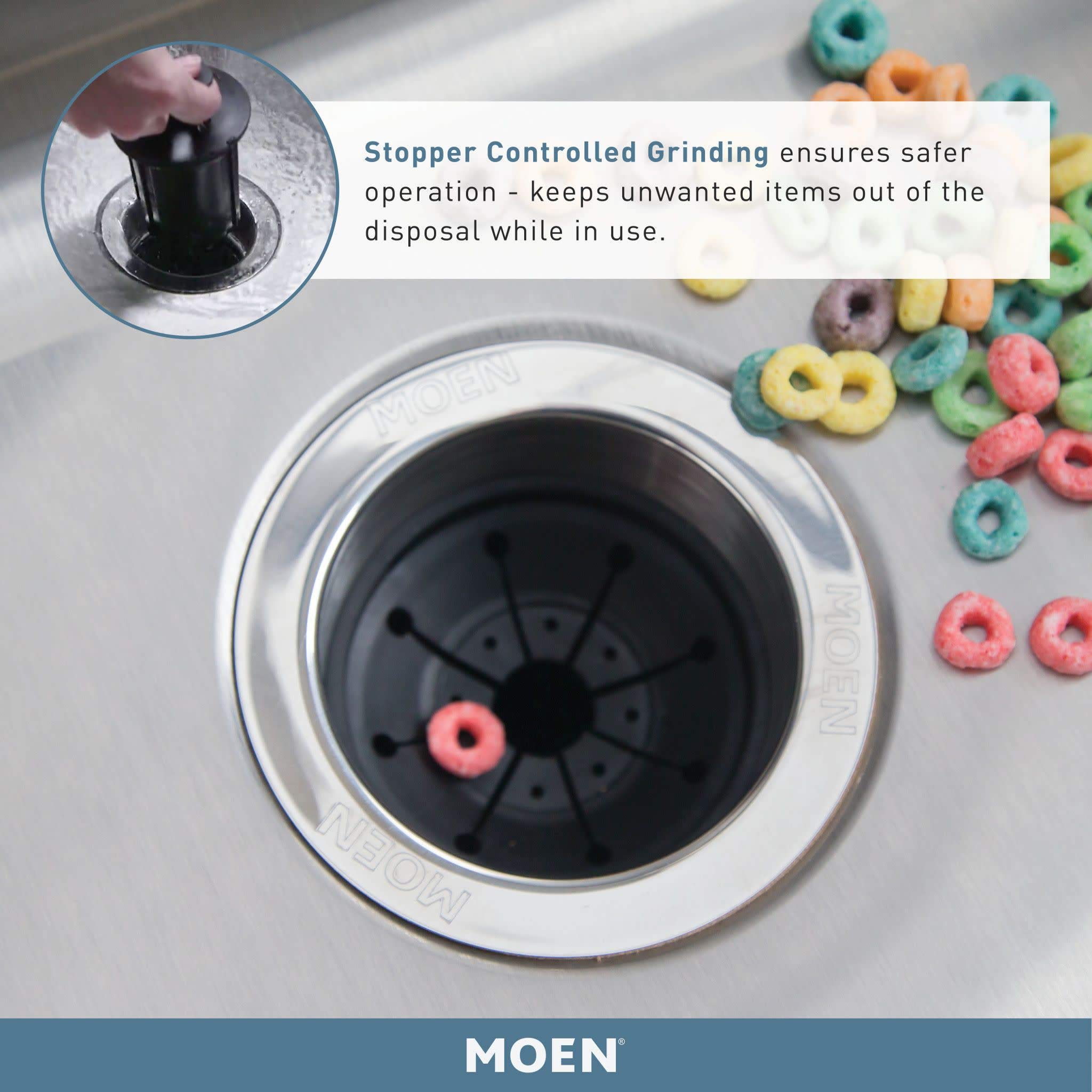 Black Moen garbage disposal sink insert with chrome rim and stopper mechanism, shown from above in kitchen sink.