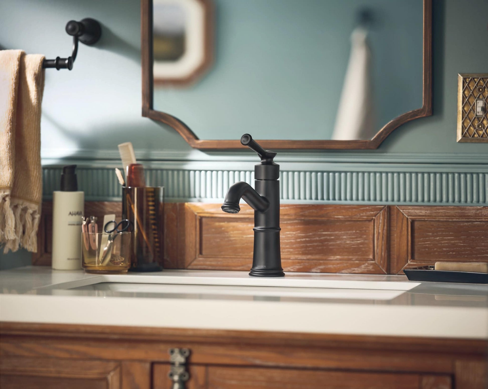 Matte black single-handle bathroom sink faucet with curved spout installed on white countertop.
