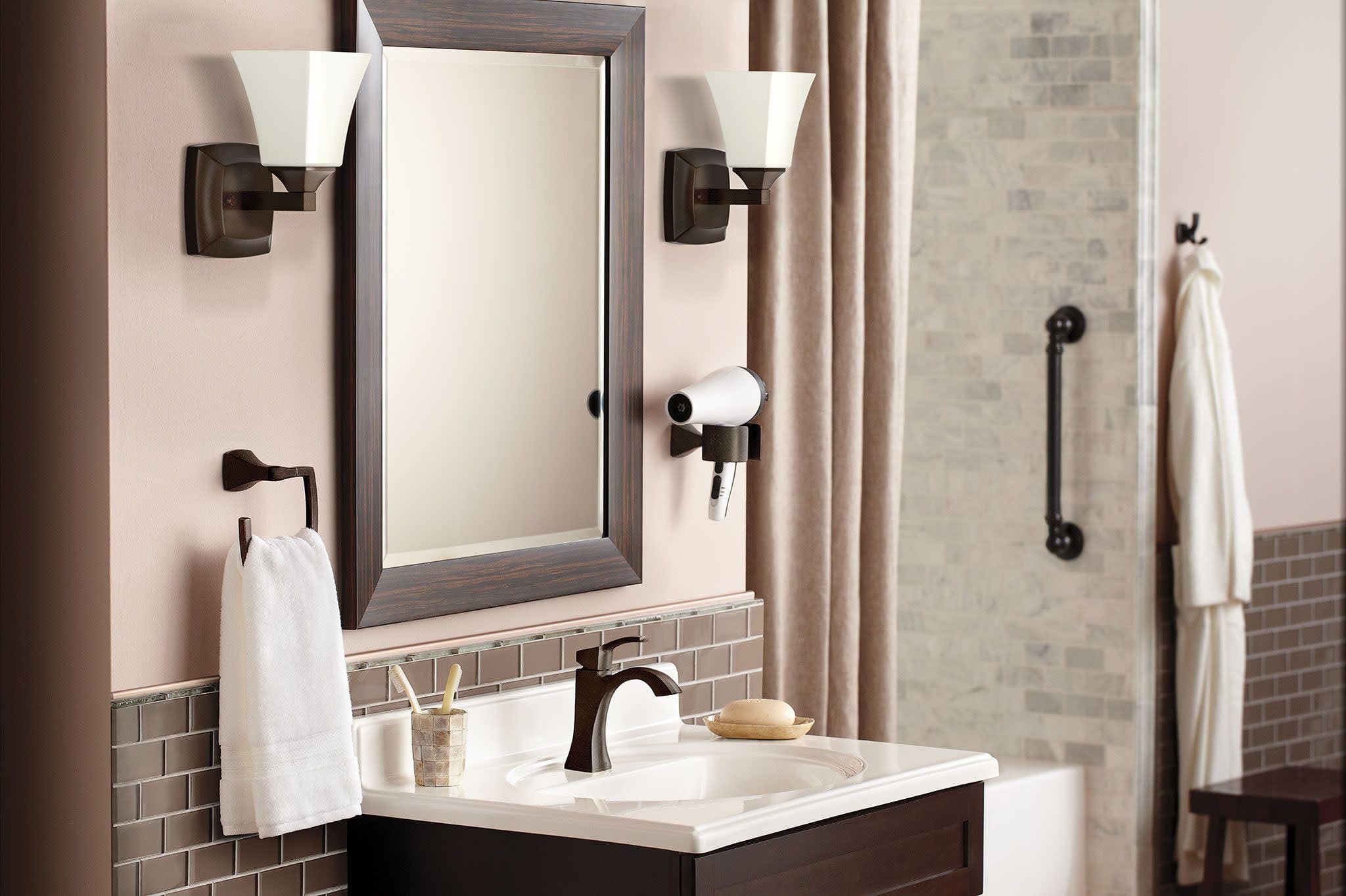 Bronze single-handle high arc bathroom faucet installed on white sink in bathroom vanity.