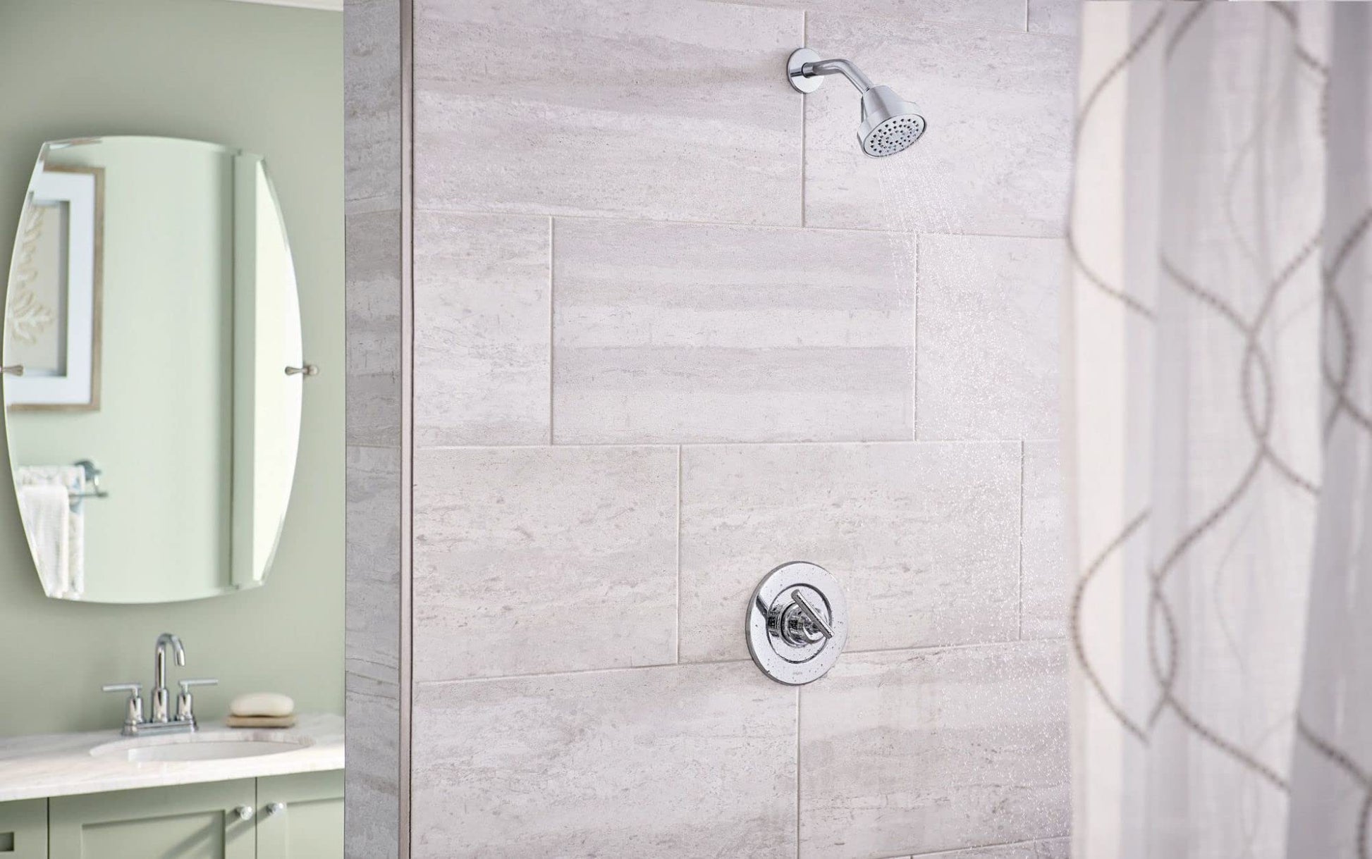 Chrome single-handle tub/shower valve with trim ring mounted on tiled shower wall.
