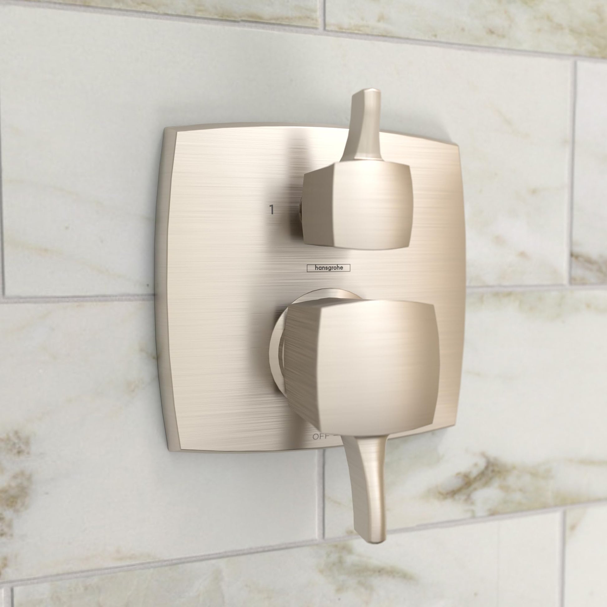 Brushed nickel square shower valve trim with dual handles and diverter mounted on marble tile.