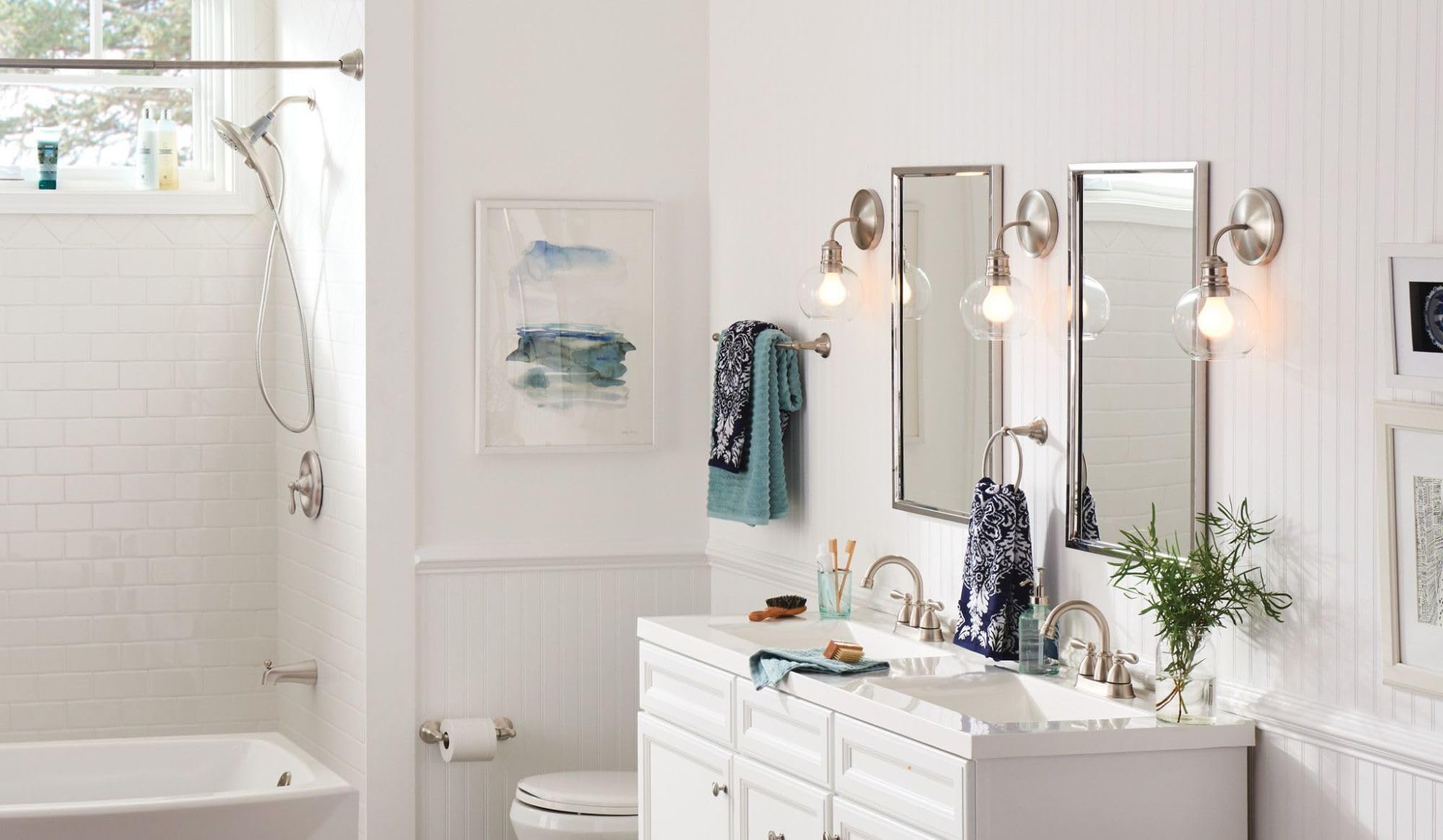Brushed nickel wall-mounted towel ring installed in a bathroom vanity area holding folded towels.