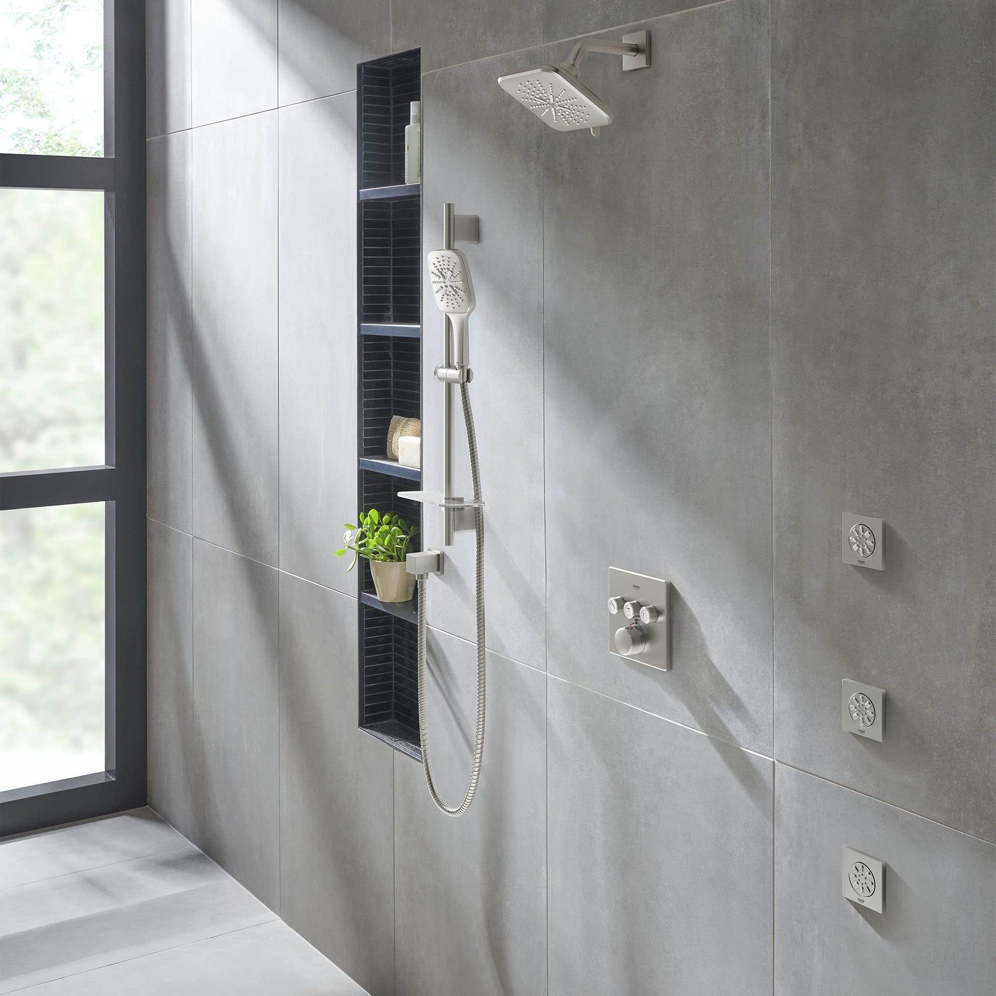 Brushed nickel shower arm mounted on gray tile wall, extending 6 inches from wall to overhead showerhead.