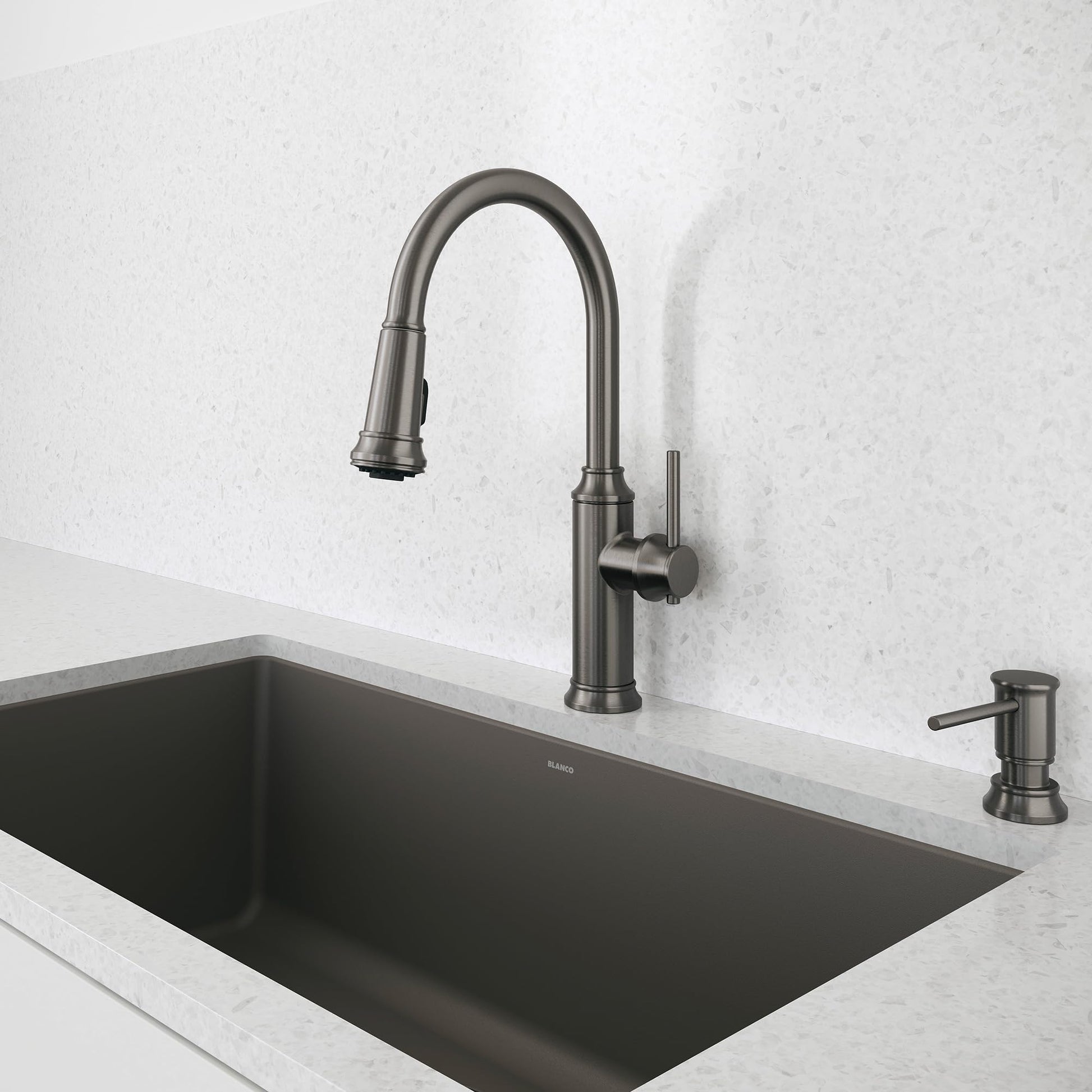 Satin dark steel pull-down kitchen faucet with curved spout and single lever handle mounted above black rectangular sink.