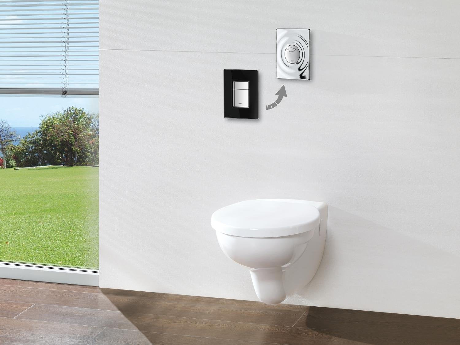 Black rectangular wall plate with circular button control mounted above white wall-mounted toilet.