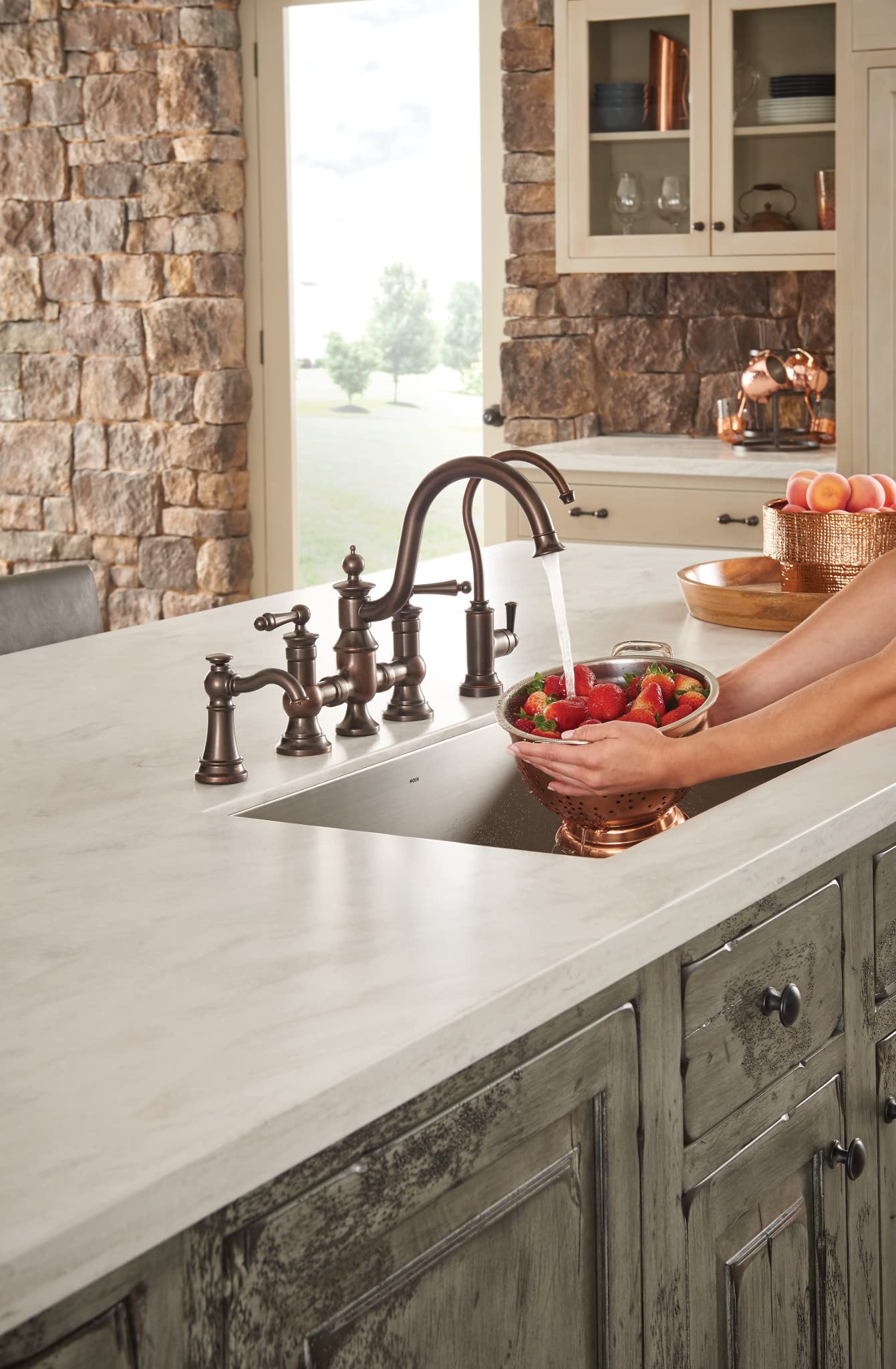 Oil rubbed bronze deck-mounted kitchen faucet with traditional curved spout and matching soap dispenser pump on white counter