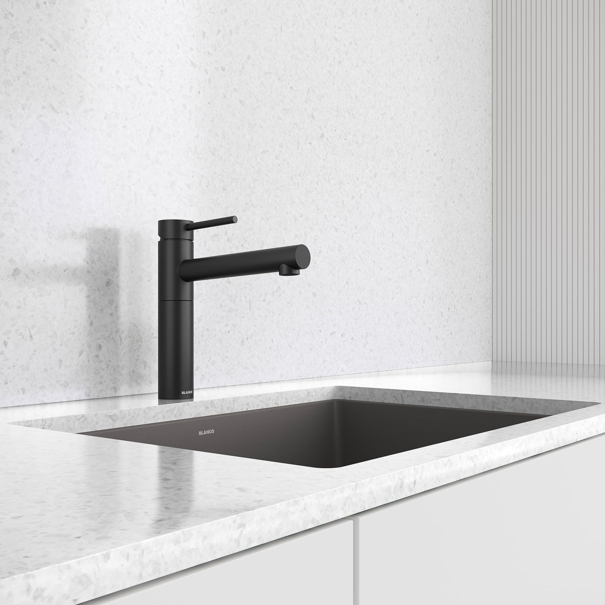 Matte black bar-style faucet with single lever handle installed above a black undermount sink on white marble countertop.