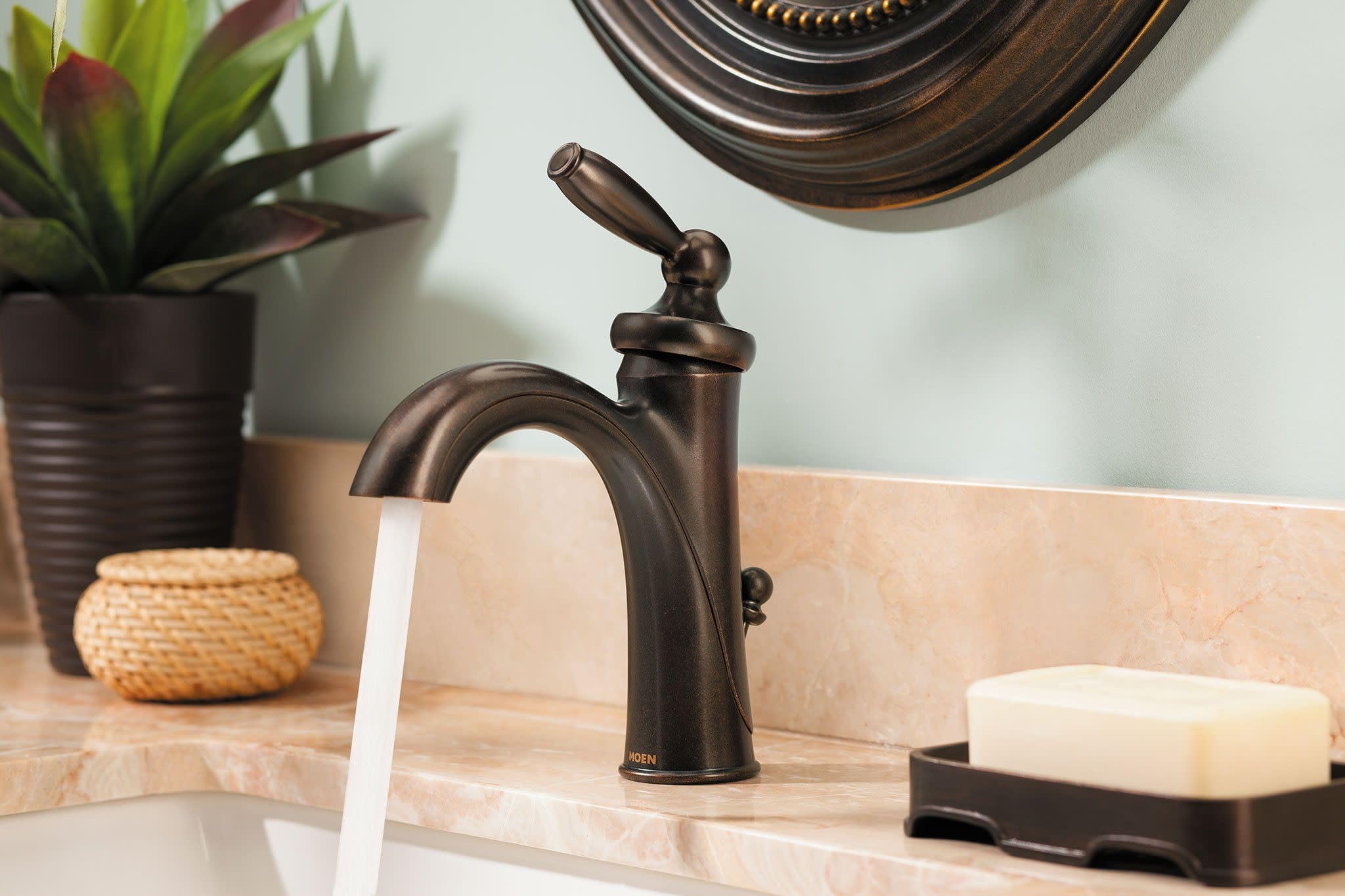 Oil-rubbed bronze single-handle bathroom faucet with low curved spout and lever handle.