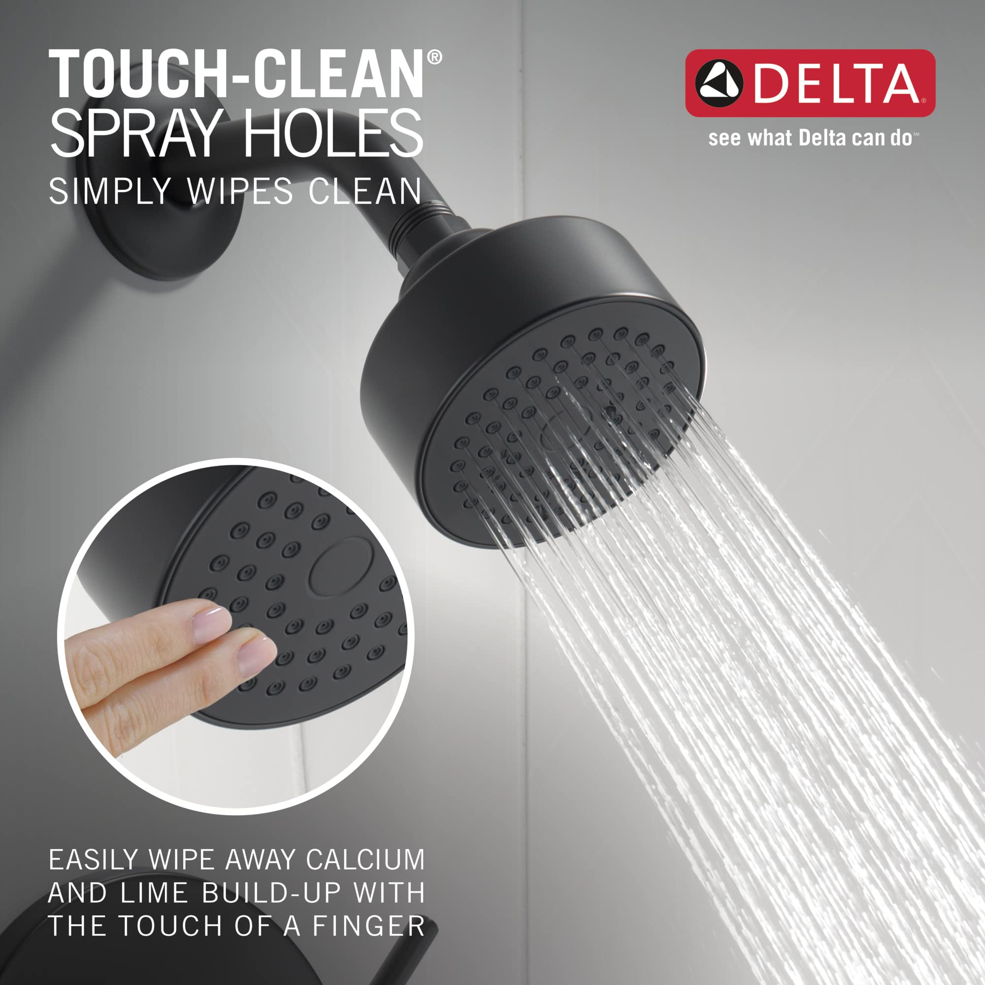 Matte black spherical showerhead with multiple spray holes and water stream flowing downward.