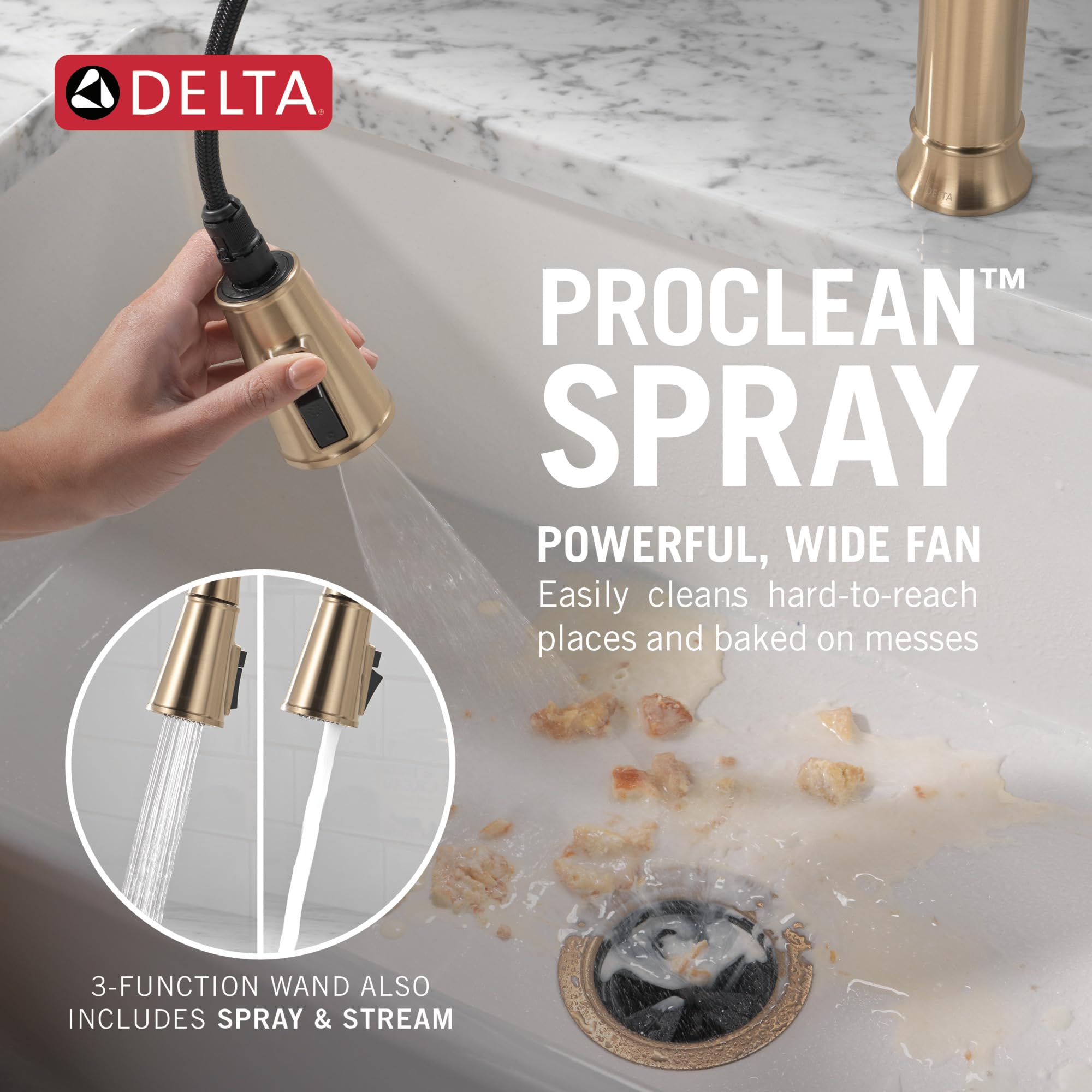 Champagne bronze pull-down kitchen faucet with single handle and spray wand over marble countertop sink.