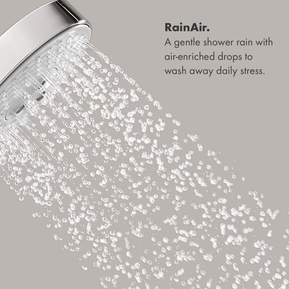 Chrome showerhead with multiple water jets in dispersed spray pattern against neutral background.