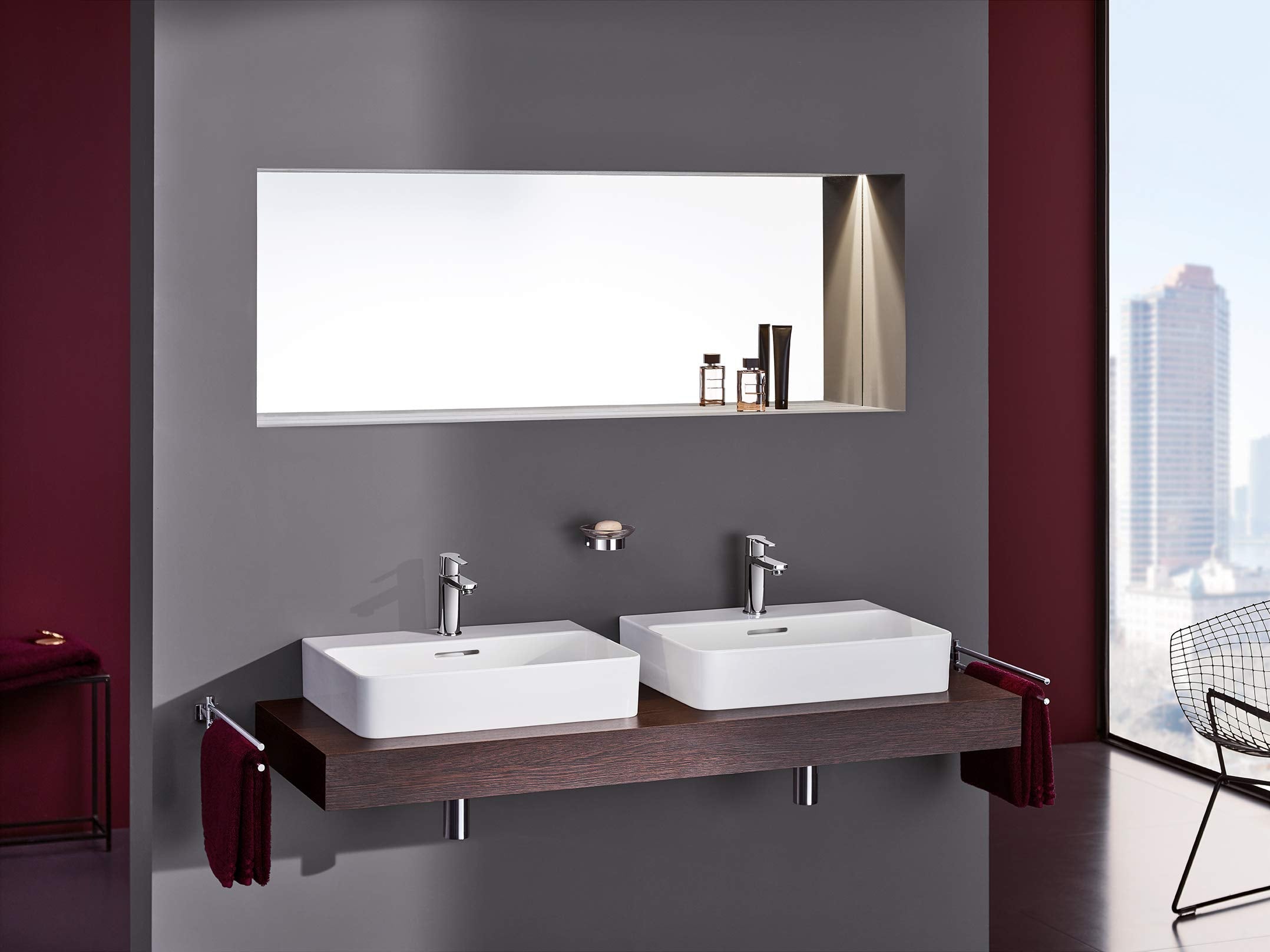 Chrome single-handle bathroom faucet with tall spout installed on white vessel sink.