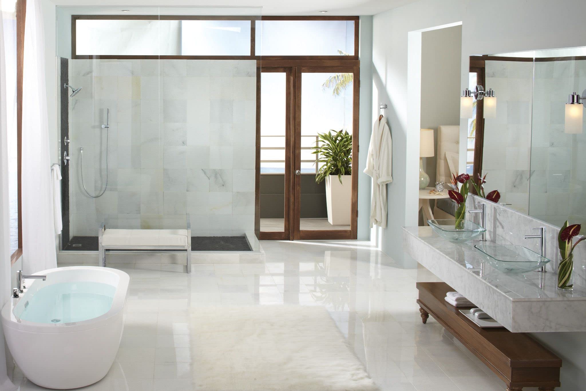 Chrome handheld showerhead with hose mounted on bathroom shower wall.
