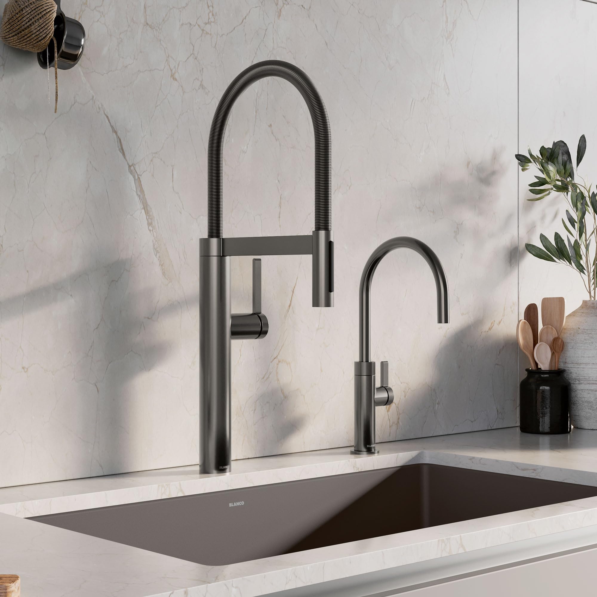Satin dark steel beverage faucet with flexible hose spray and separate smaller faucet installed above kitchen sink.