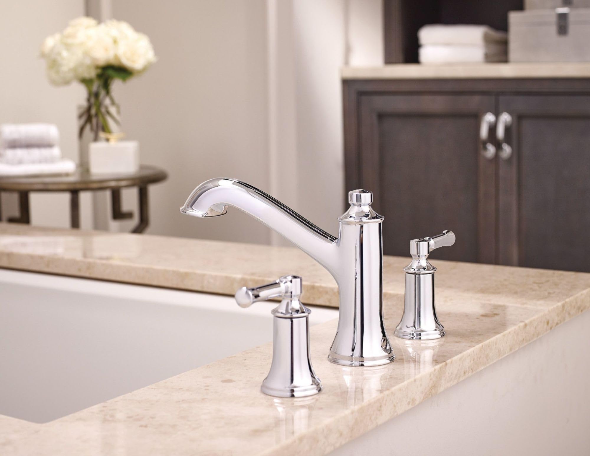 Brushed nickel two-handle high arc roman tub faucet with curved spout and lever handles mounted on marble countertop.