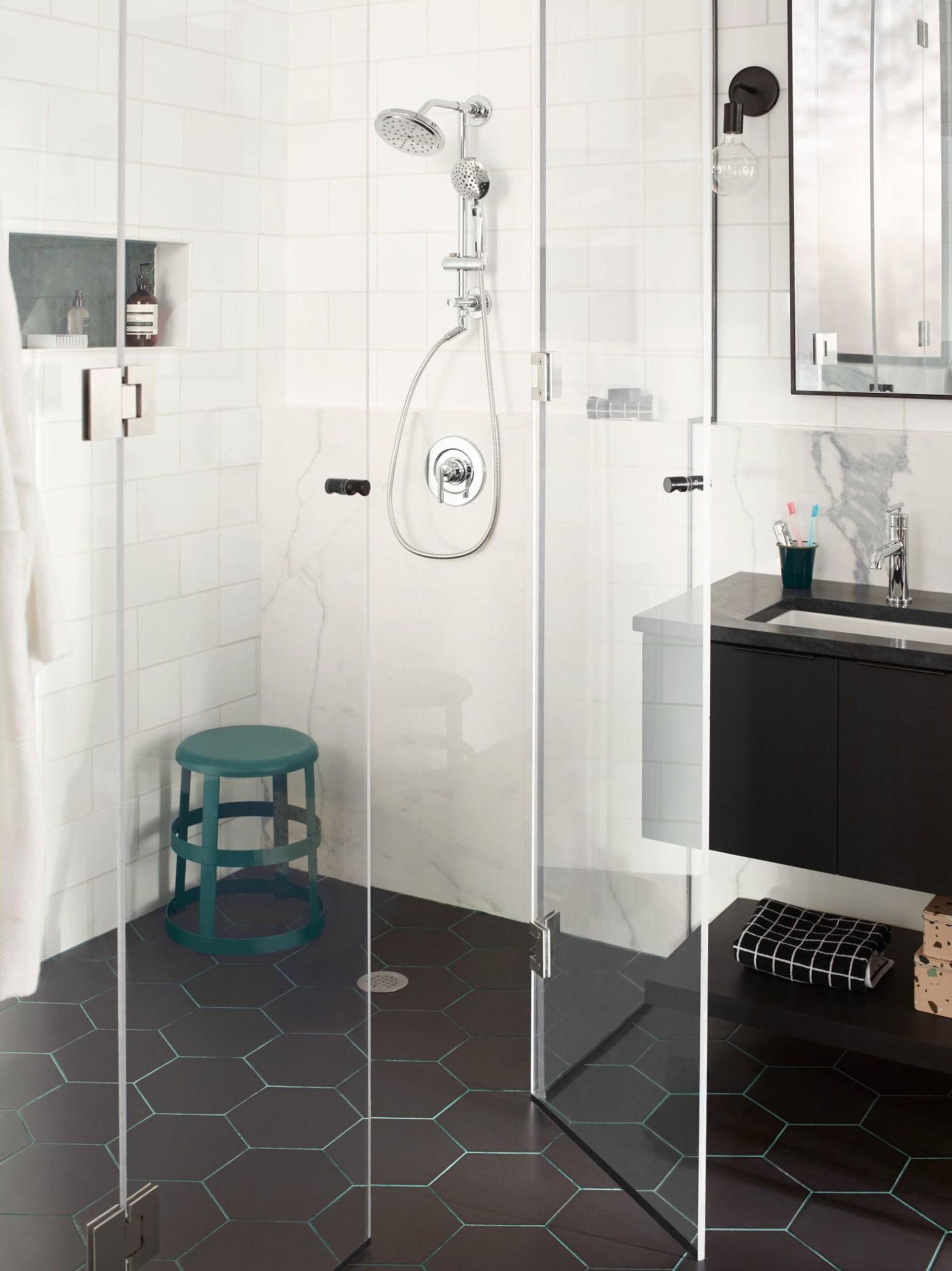 Chrome shower system with fixed showerhead, handheld shower on sliding bar, and control valve mounted on tile wall.
