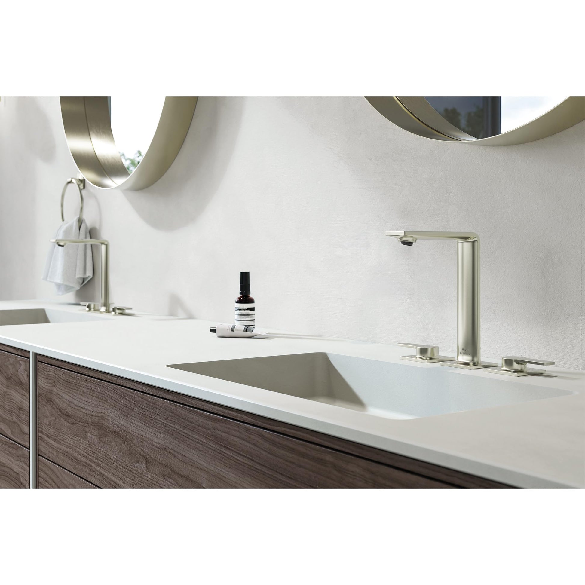 Chrome widespread bathroom faucet with two handles mounted on white countertop above rectangular sink.