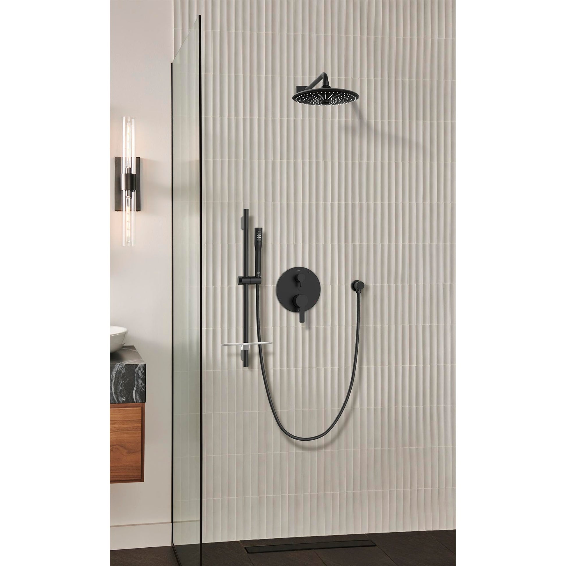 Matte black shower valve trim with round control handle, overhead rainfall showerhead, handheld wand, and diverter mounted on