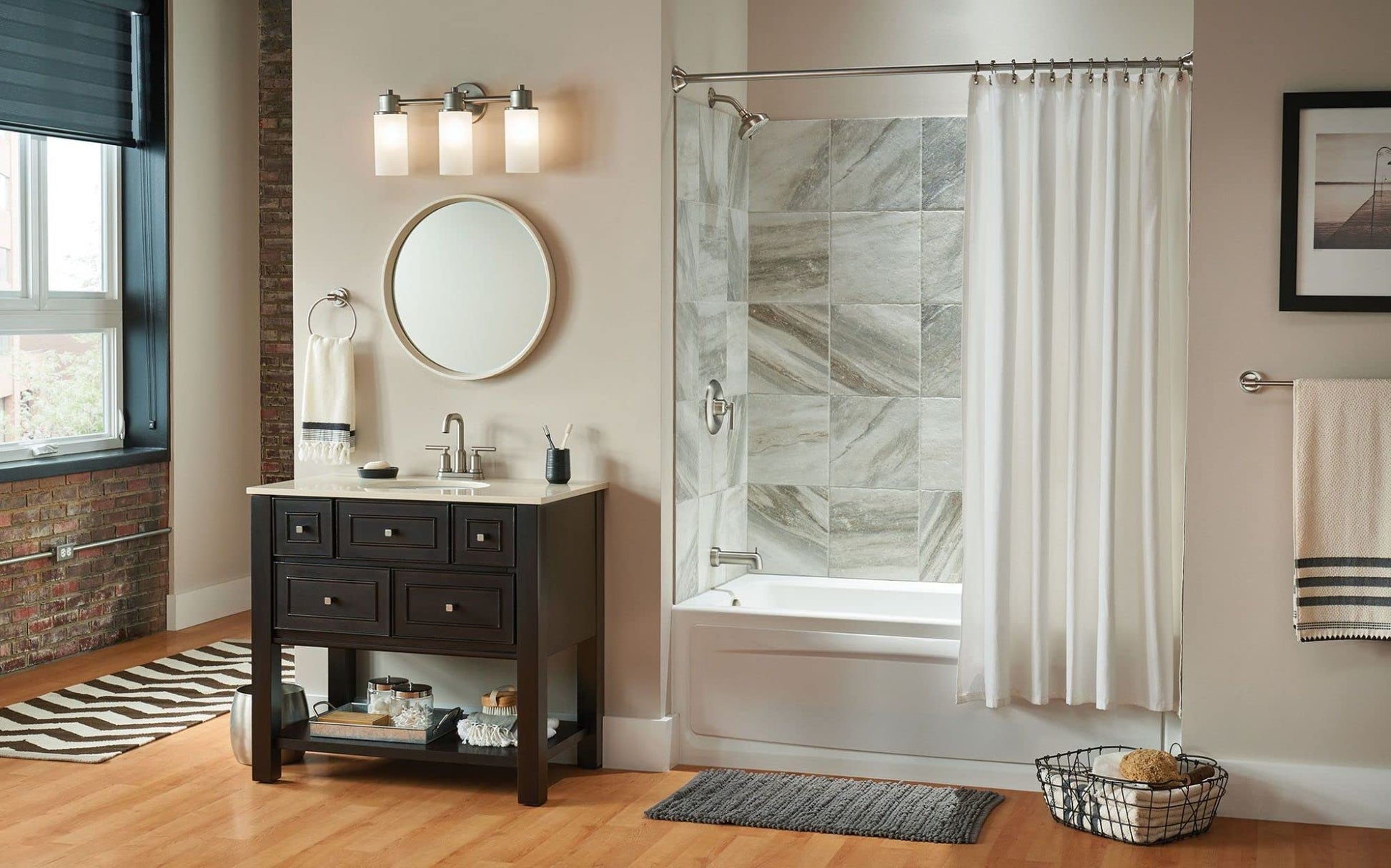 Brushed nickel wall-mounted circular towel ring installed beside bathroom vanity mirror.