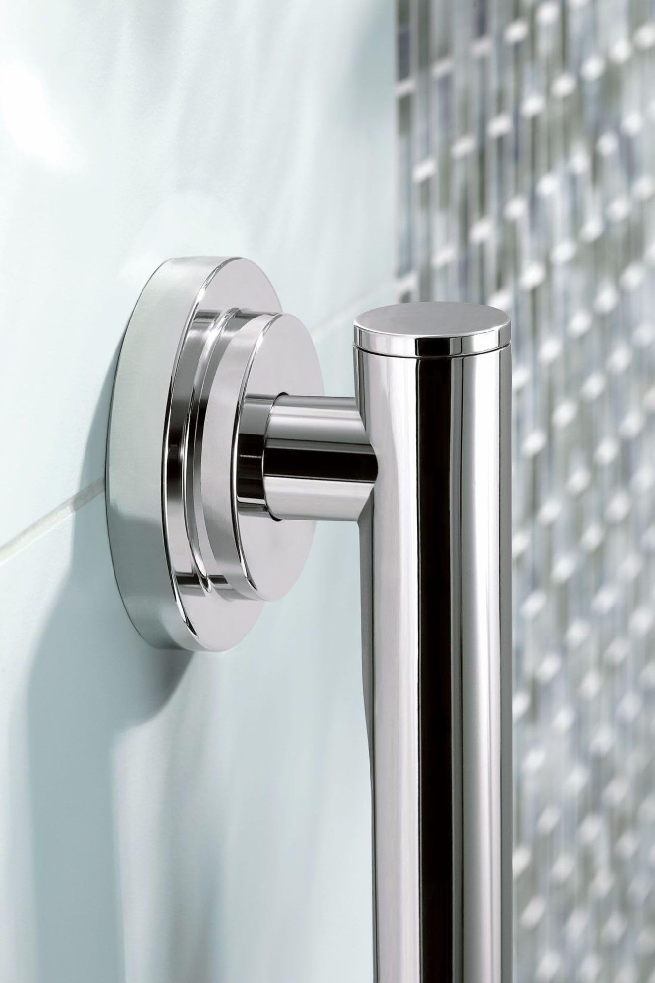 Chrome wall-mounted grab bar with cylindrical grip and round mounting flange installed on white tile wall.