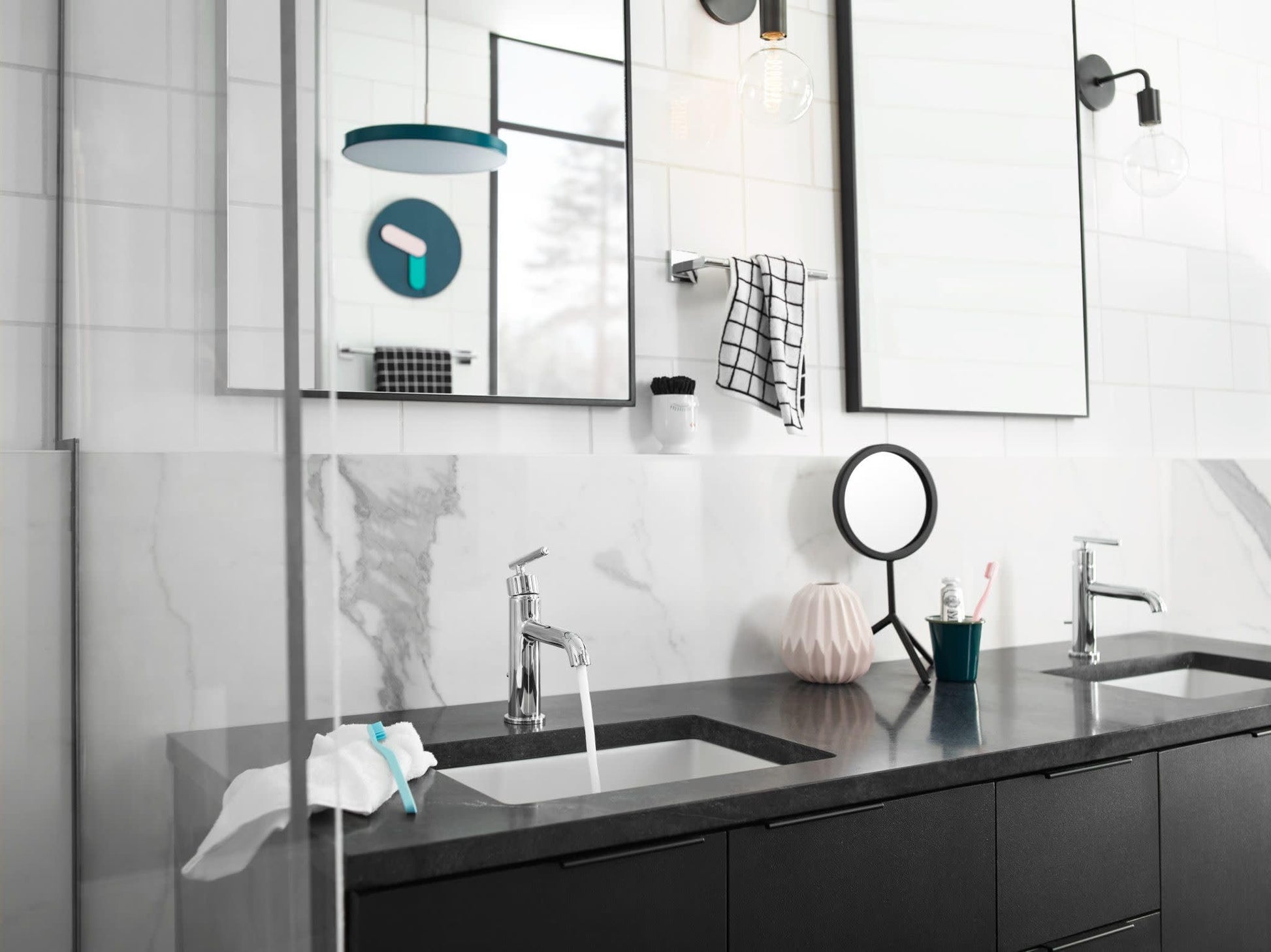 Chrome single-handle bathroom faucet with curved spout installed on black vanity counter with white sink.