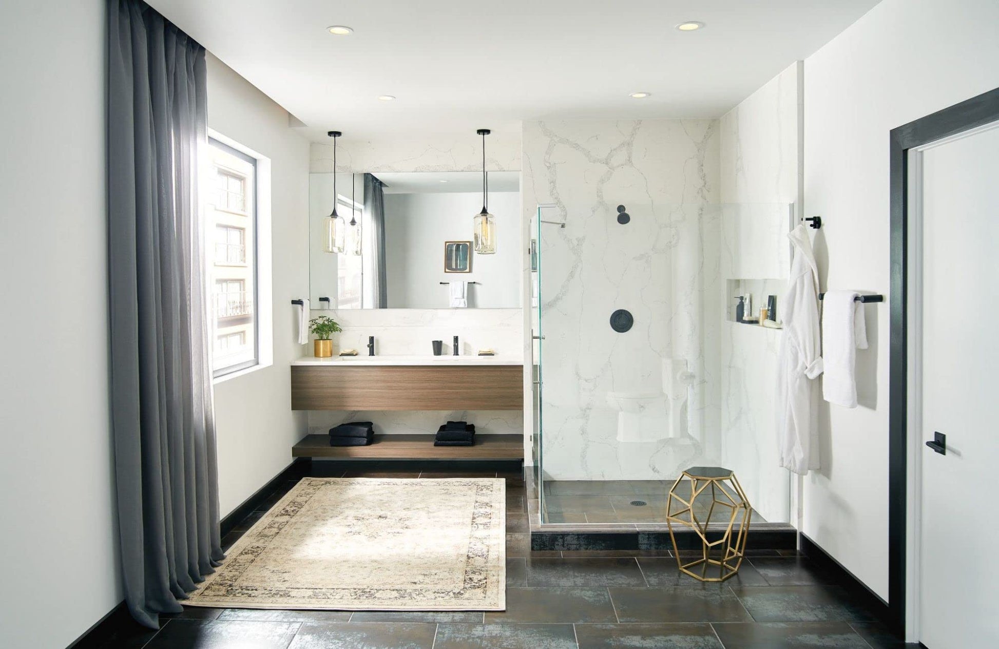 Black hand towel bar mounted on white marble shower wall in modern bathroom.