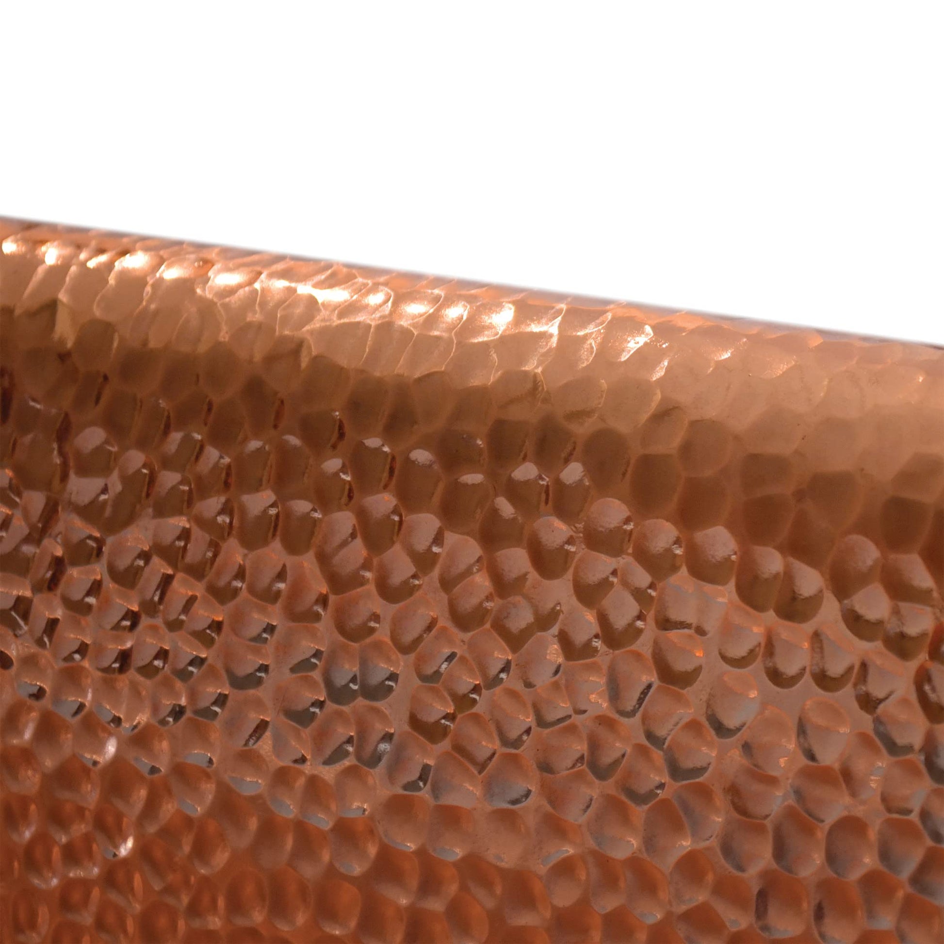 Antique copper bathtub with hammered texture surface in warm brown-orange tone.