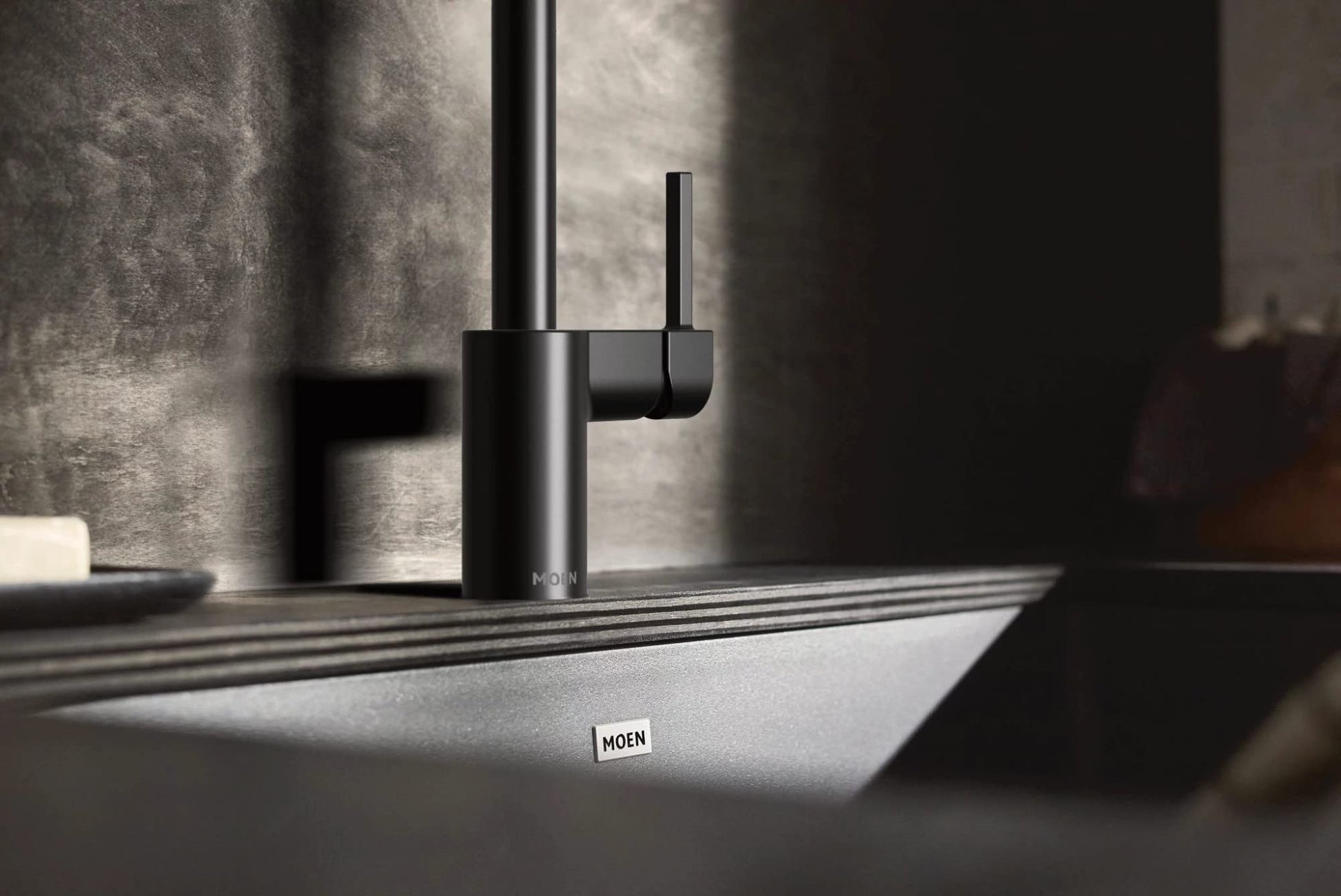 Matte black granite undermount kitchen sink with single bowl and matte black faucet.