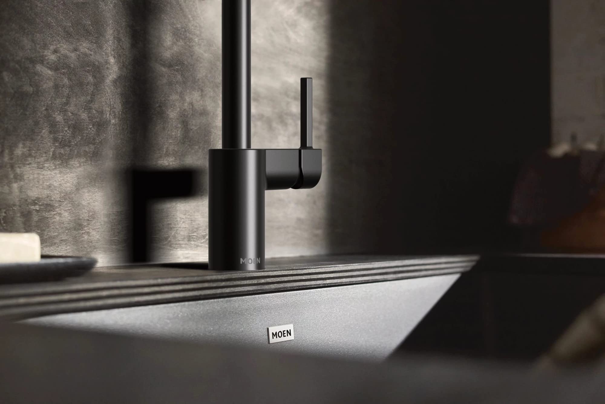 Matte black granite undermount kitchen sink with single bowl and matte black faucet.