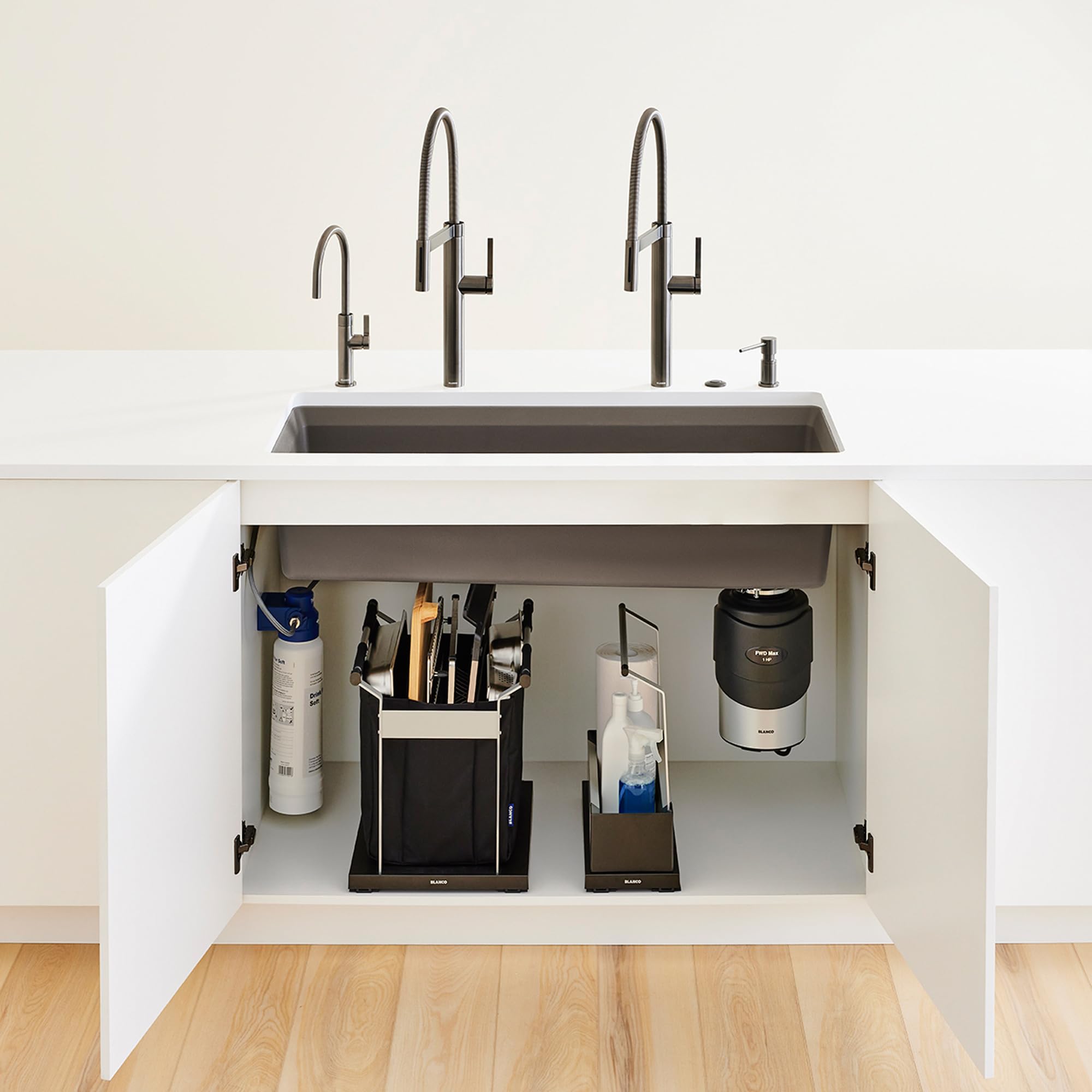 Black sink storage organizer with compartments holding utensil holder, spray bottle, and accessories under kitchen sink.