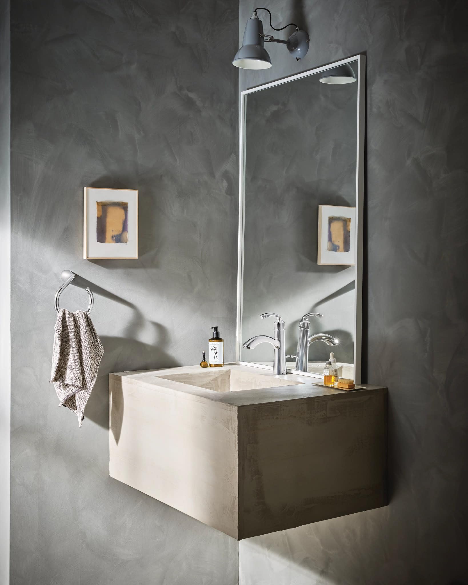 Chrome single-handle bathroom sink faucet with curved spout installed on bathroom vanity.