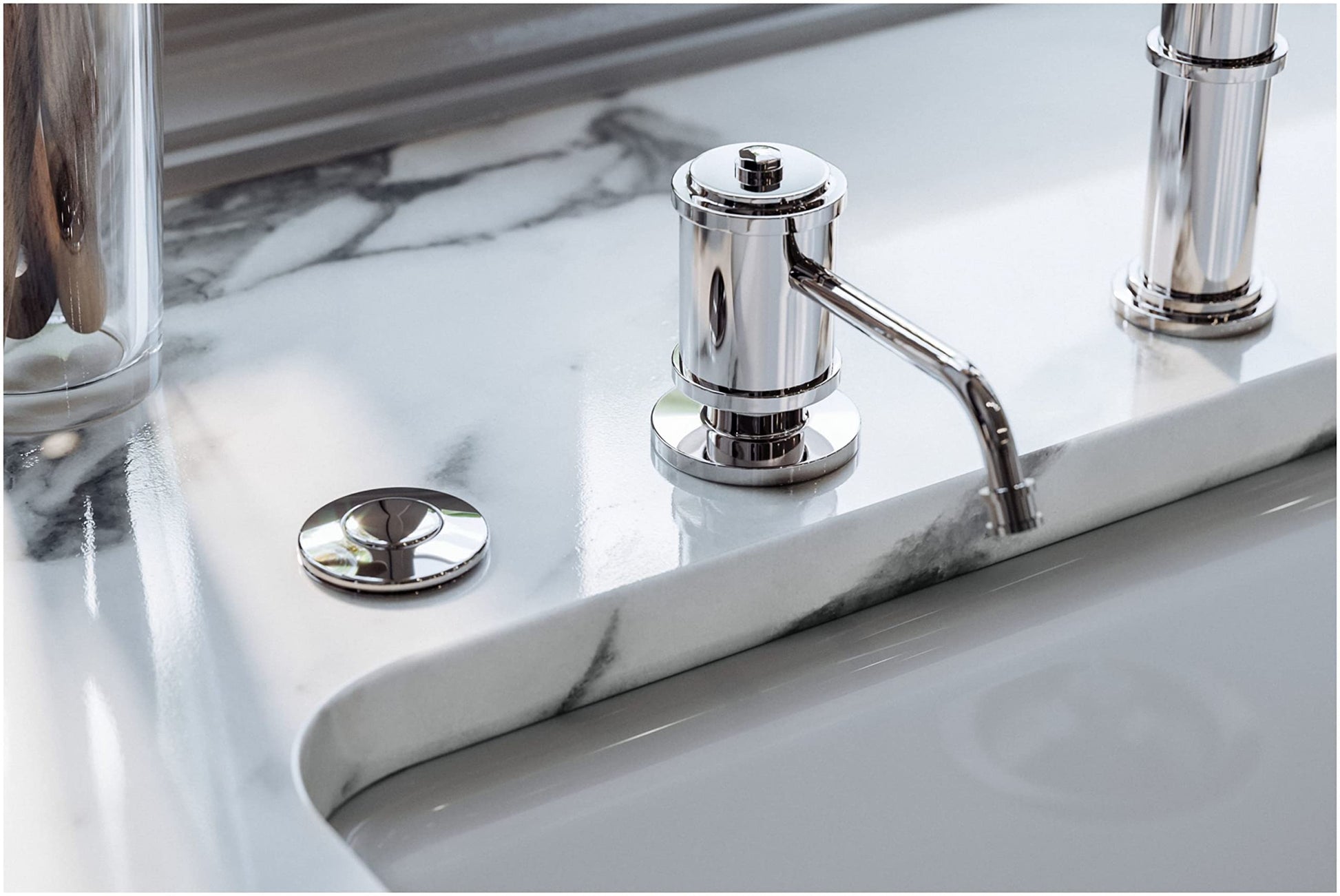 Polished chrome soap dispenser with cylindrical pump mounted on marble countertop next to sink.