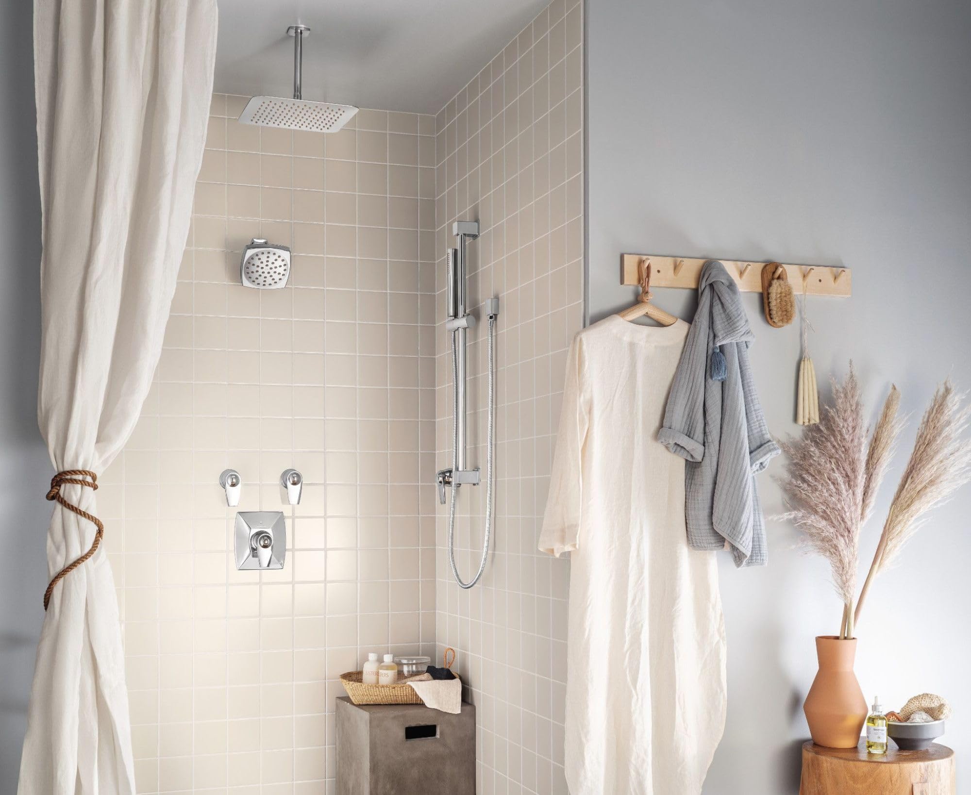 Chrome square rain shower head mounted on ceiling above bathroom shower enclosure.