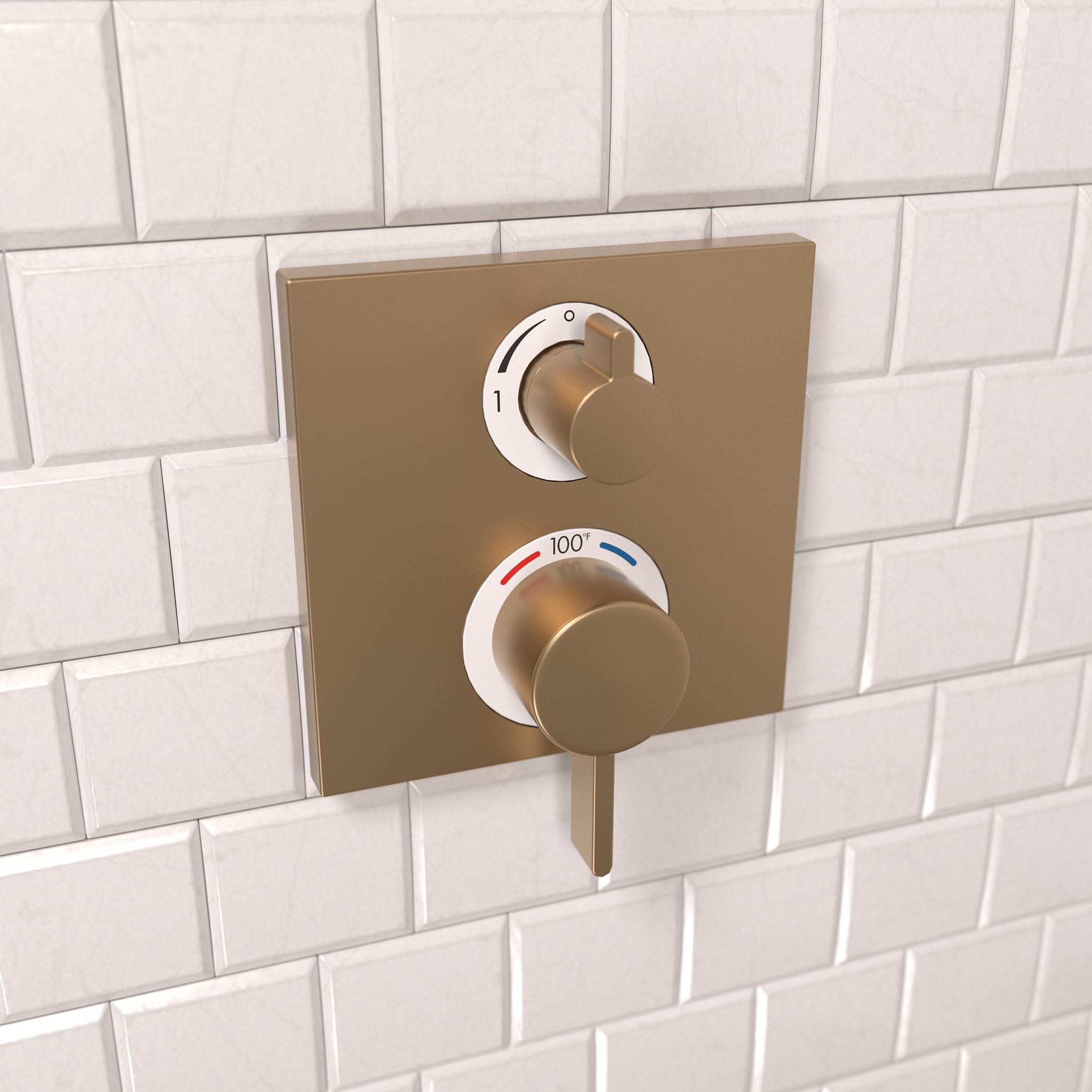Brushed bronze thermostatic shower trim with two control knobs mounted on white subway tile wall.