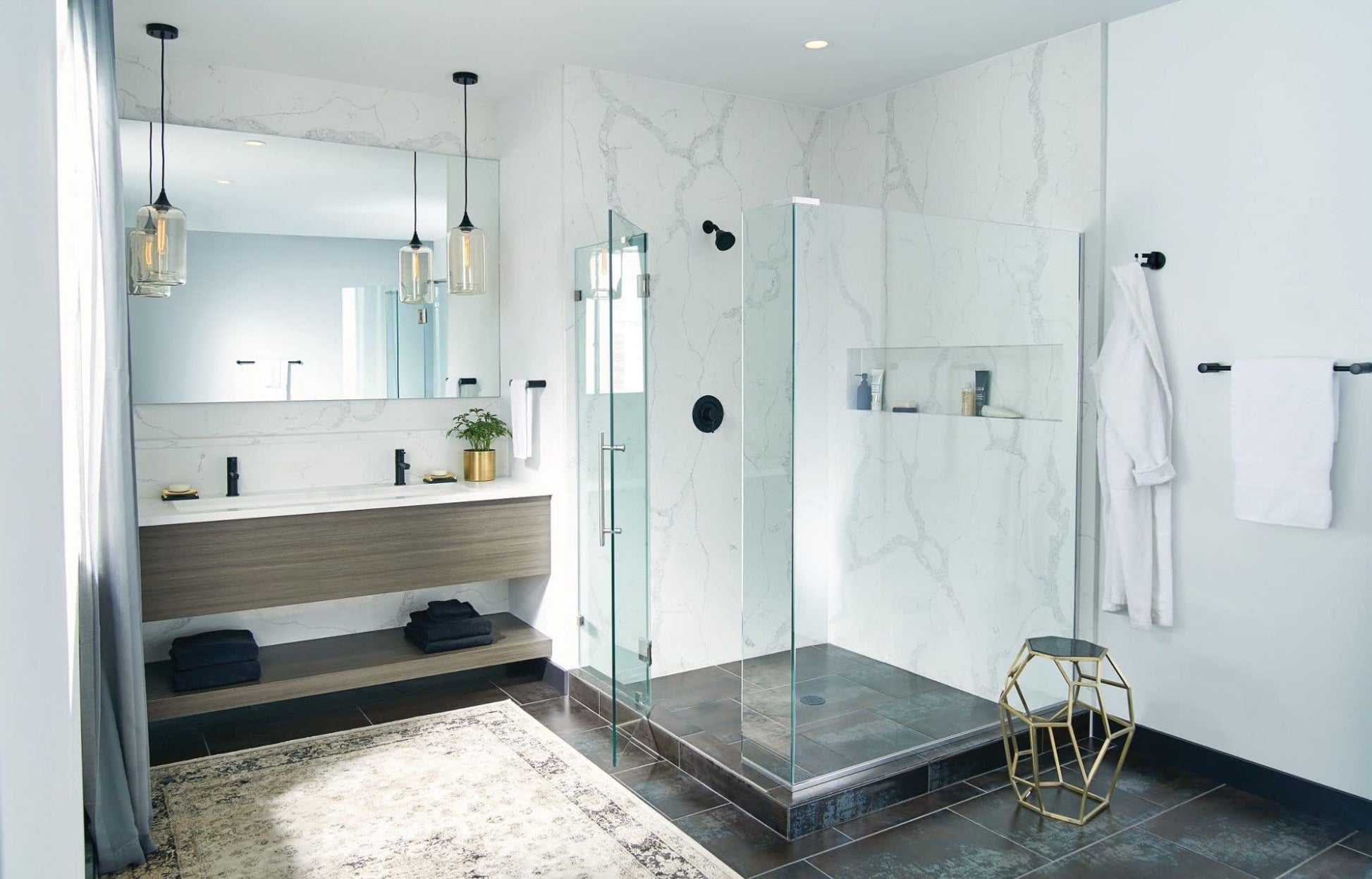 Black hand towel bar mounted on marble bathroom wall next to glass shower enclosure.