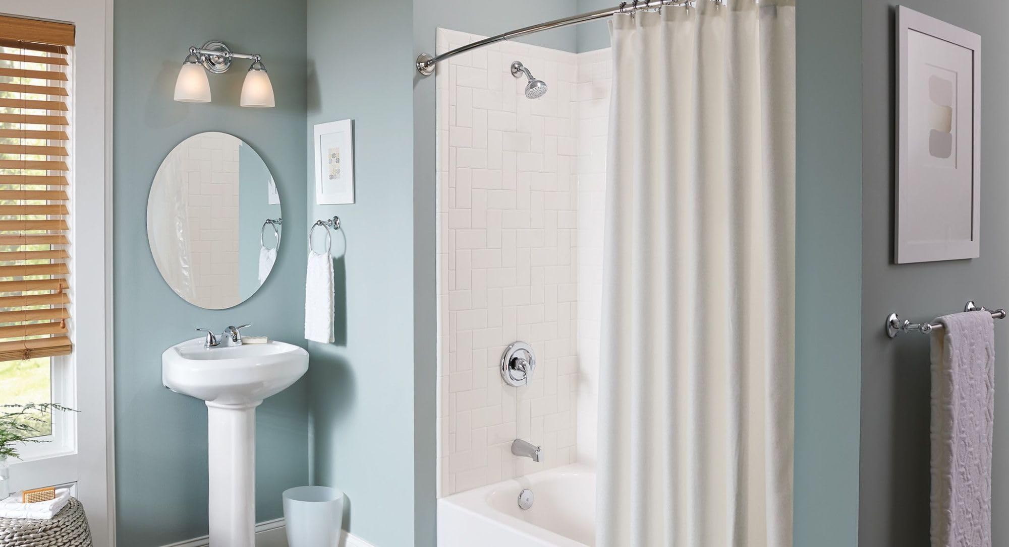 Chrome single-handle tub and shower trim kit with showerhead and spout mounted on bathroom wall above bathtub.