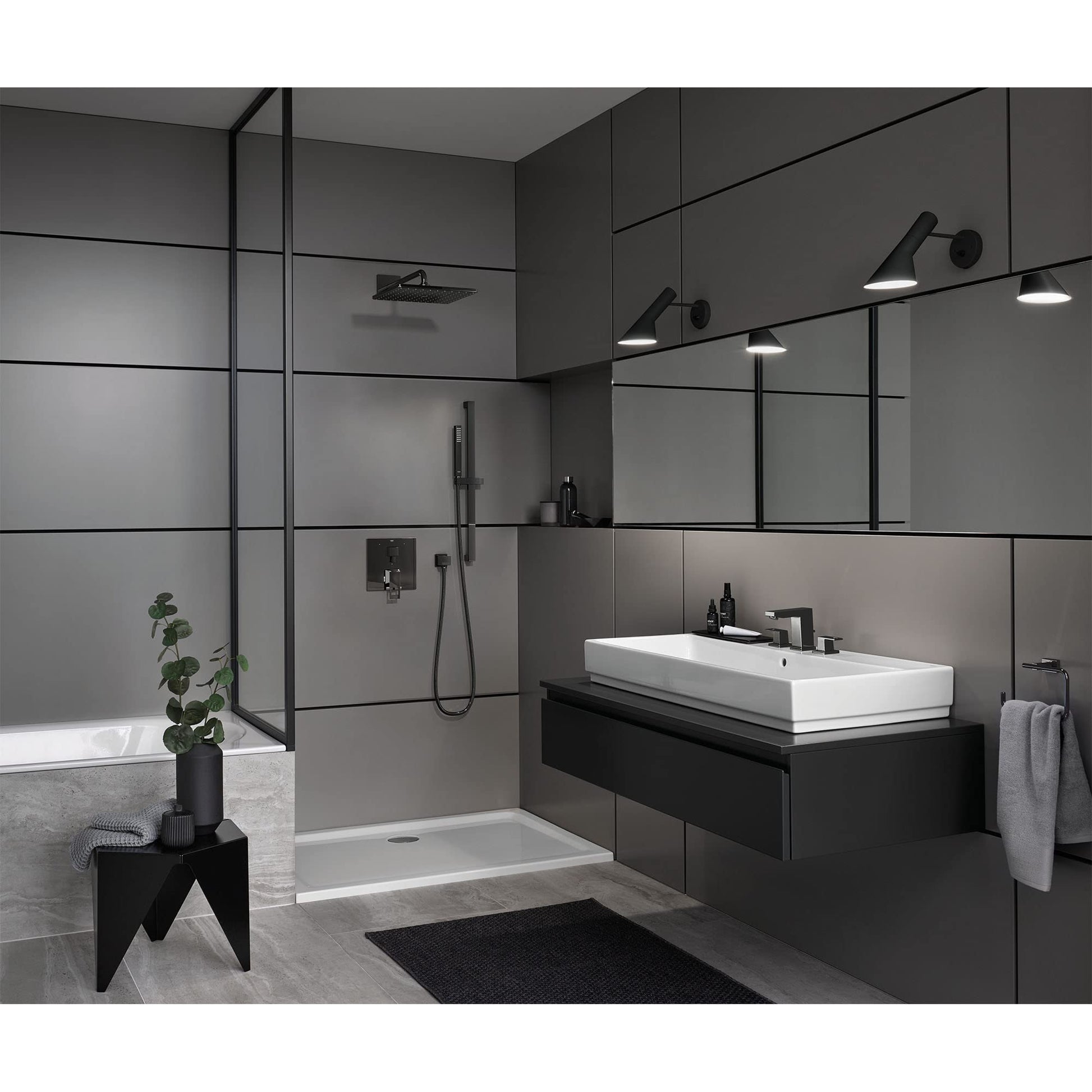 Dark graphite wall-mounted shower union fitting displayed in a modern bathroom setting with shower enclosure and fixtures.