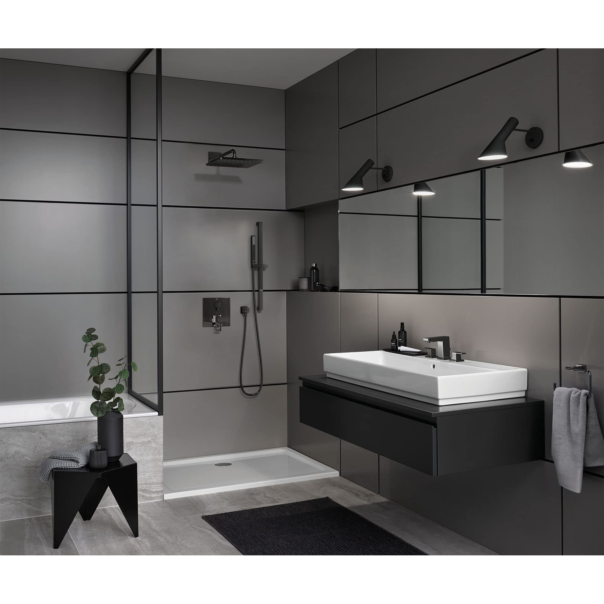 Dark graphite wall-mounted shower union fitting displayed in a modern bathroom setting with shower enclosure and fixtures.