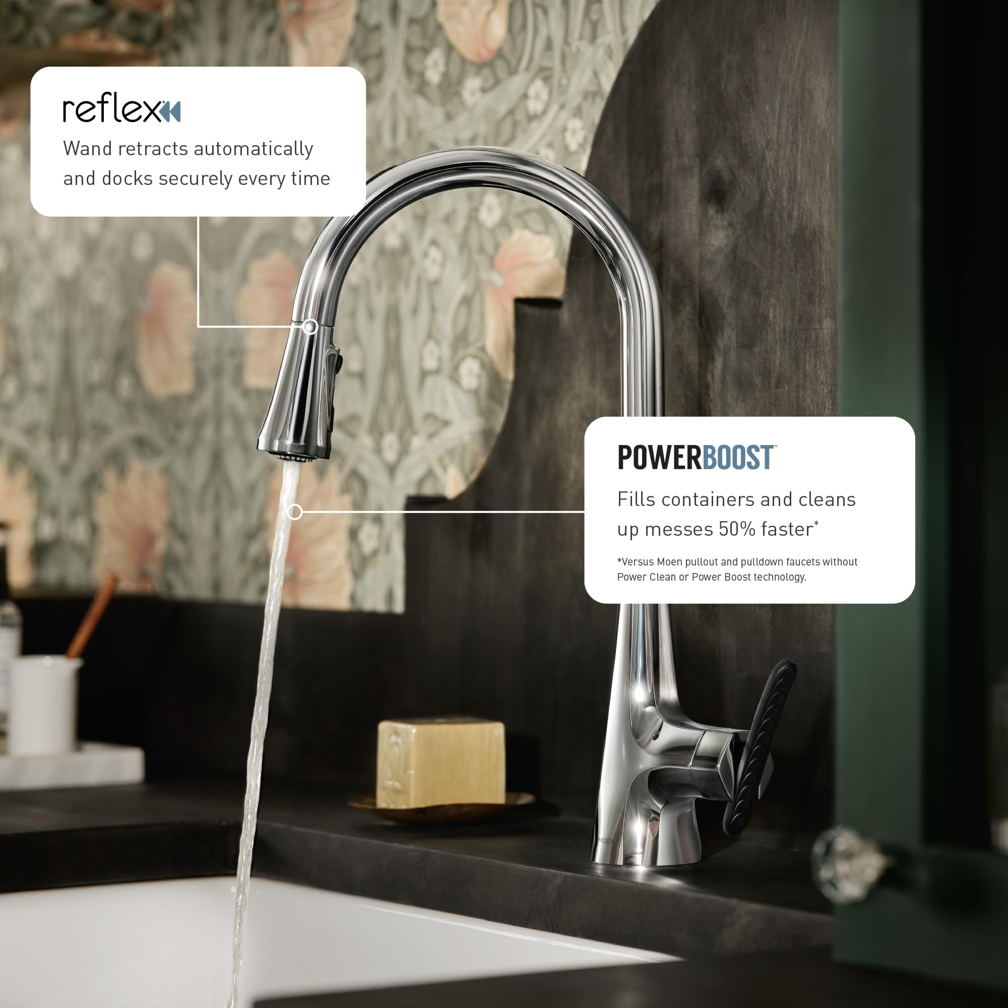 Chrome pulldown kitchen faucet with two handles mounted on black sink with water flowing from extended wand.