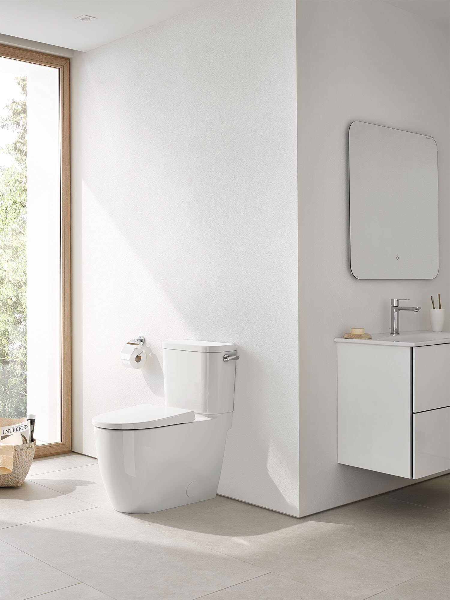 White two-piece elongated toilet with seat and right-hand trip lever installed in bathroom.