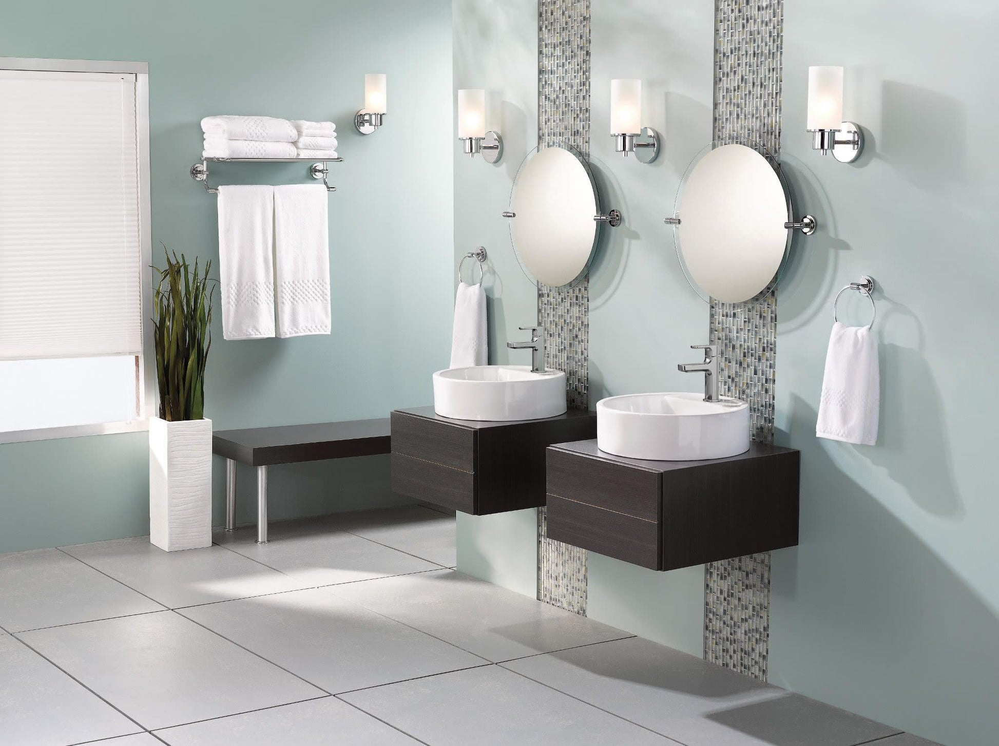 Chrome single-handle bathroom faucet with curved spout mounted on white vessel sink in modern vanity setting.