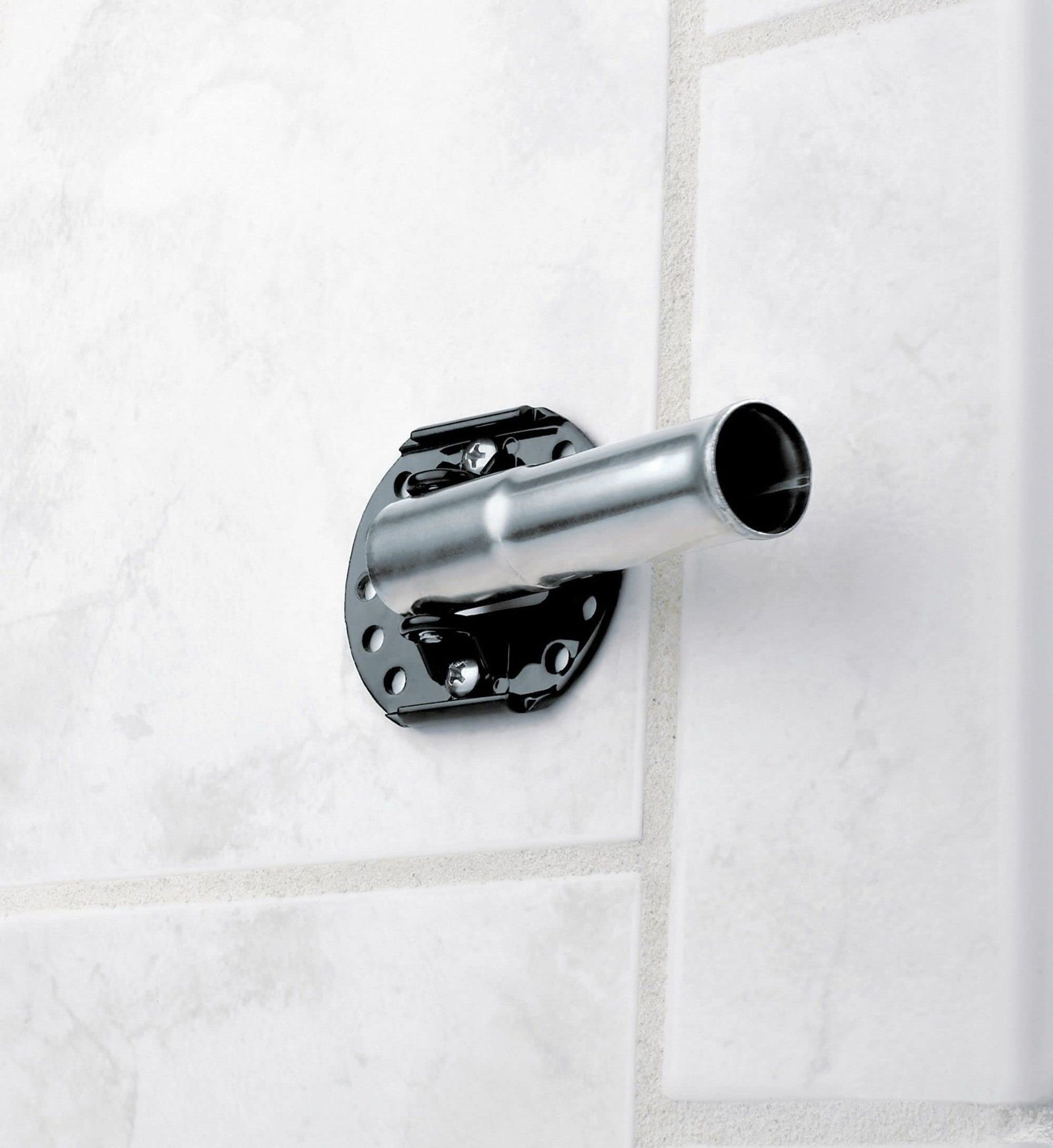 Chrome curved shower rod with black mounting bracket installed on white tiled wall.