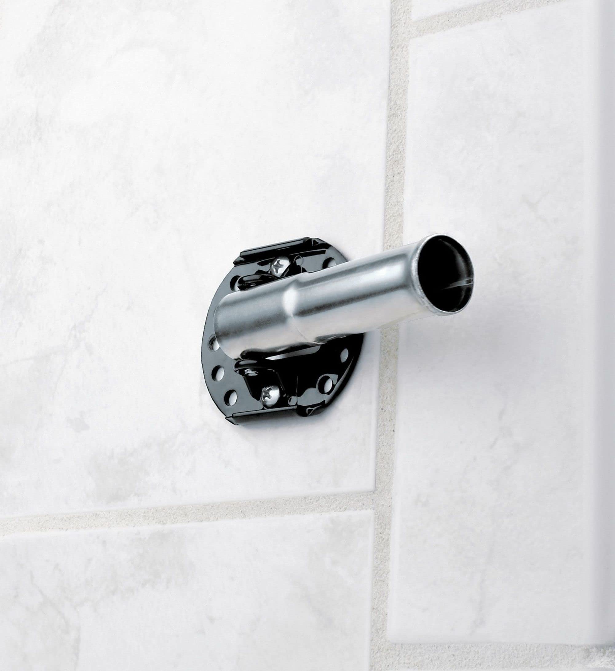 Chrome curved shower rod with black mounting bracket installed on white tiled wall.