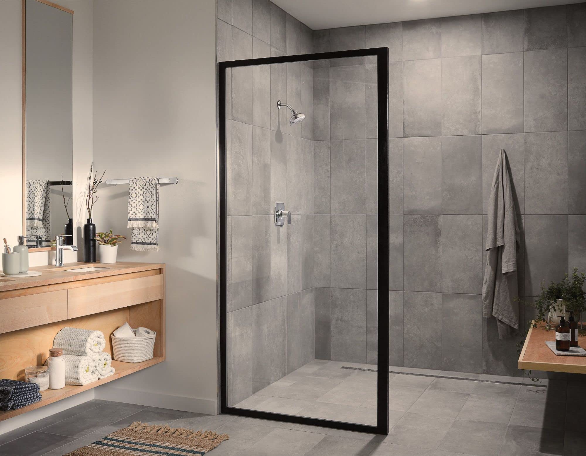 Chrome single-handle shower valve trim with lever handle mounted on gray tiled shower wall.