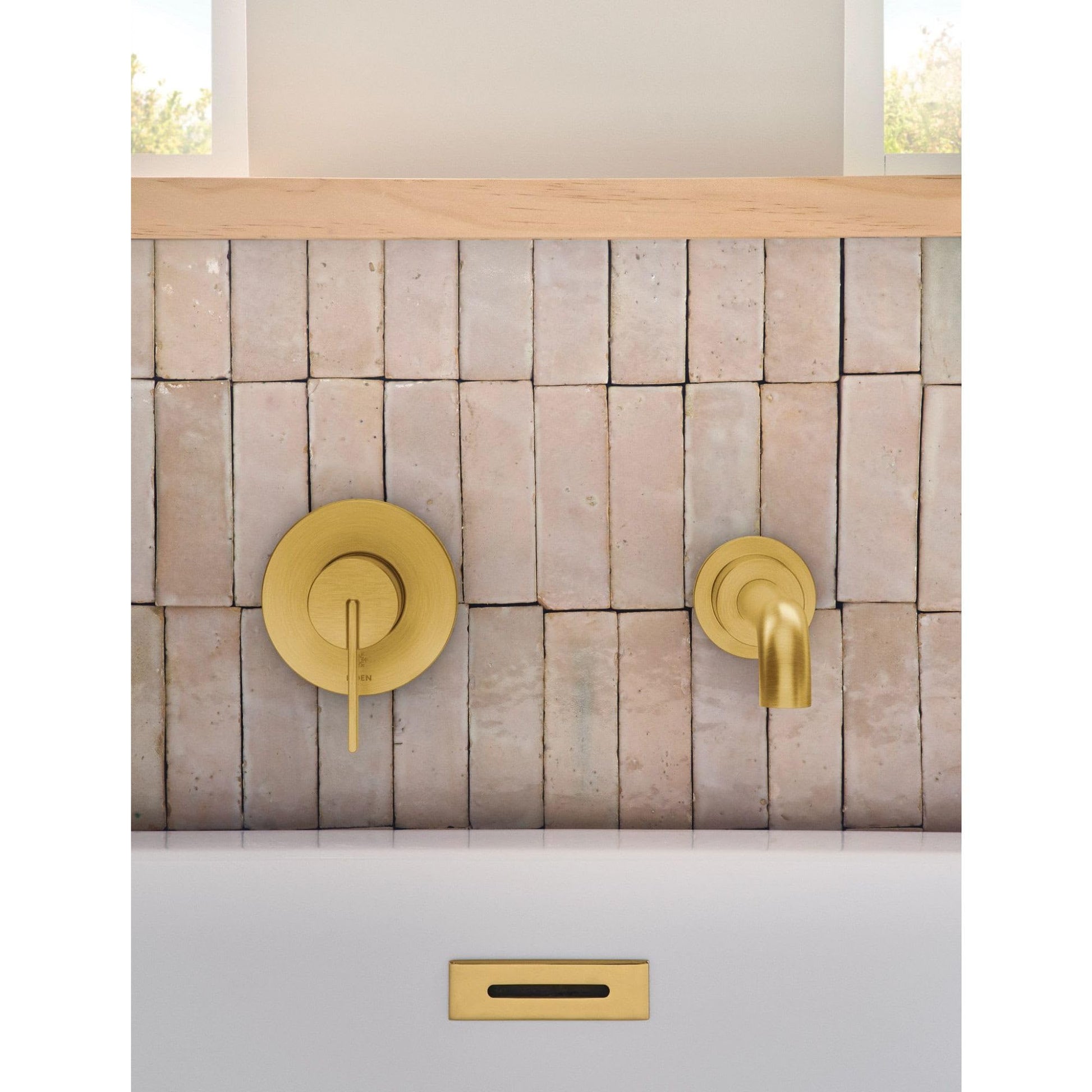 Matte black wall-mounted tub faucet with single handle and curved spout installed on vertical tile wall.