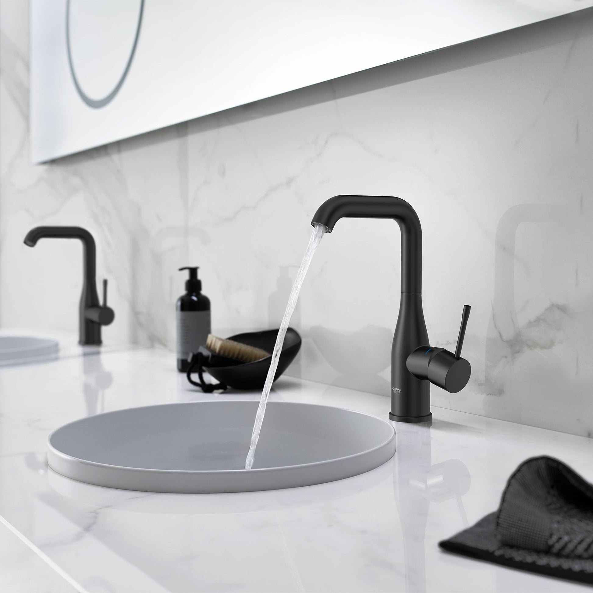 Matte black single-handle bathroom faucet with tall curved spout dispensing water into round sink basin.