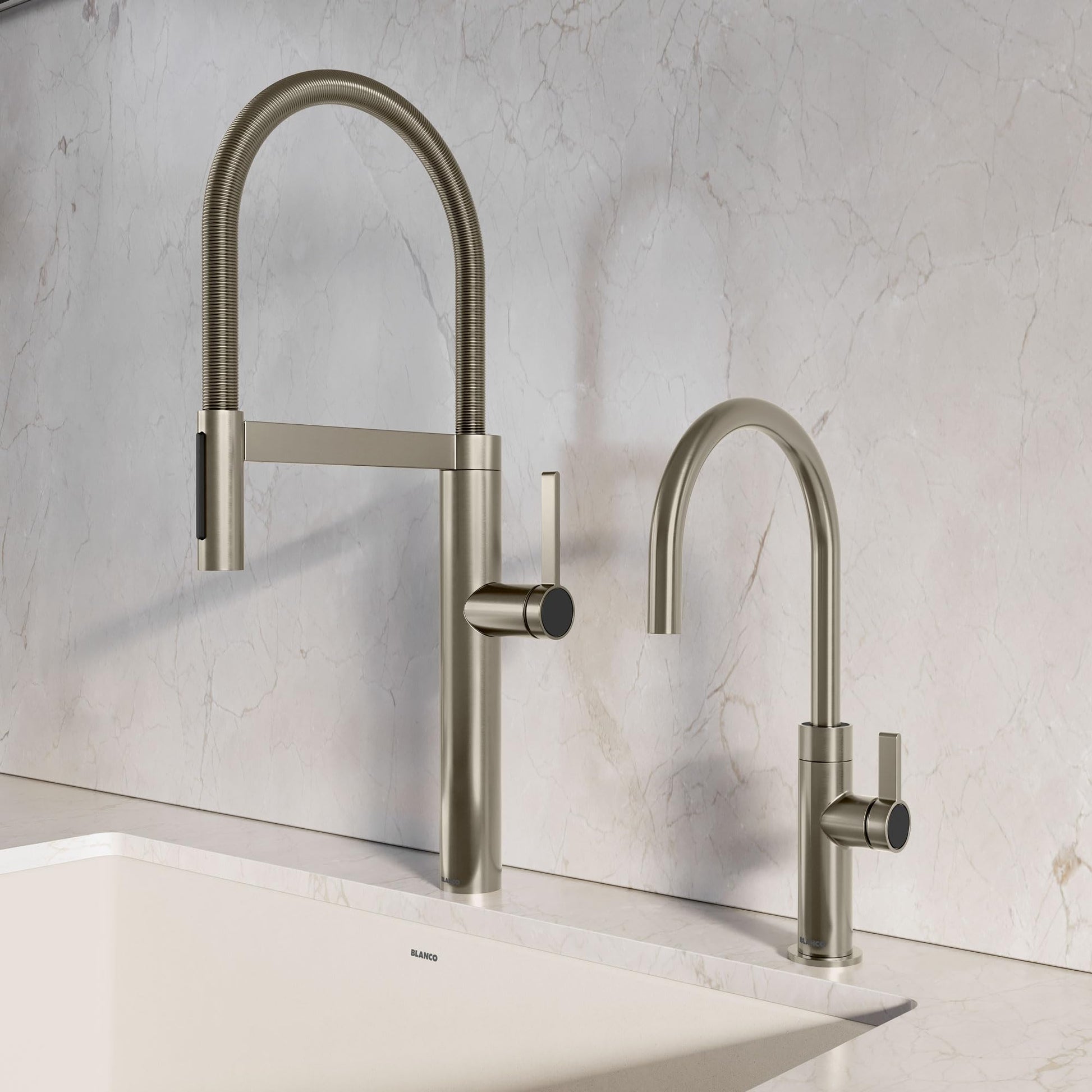 Satin platinum kitchen faucet with flexible hose and separate spray head mounted on white marble countertop.
